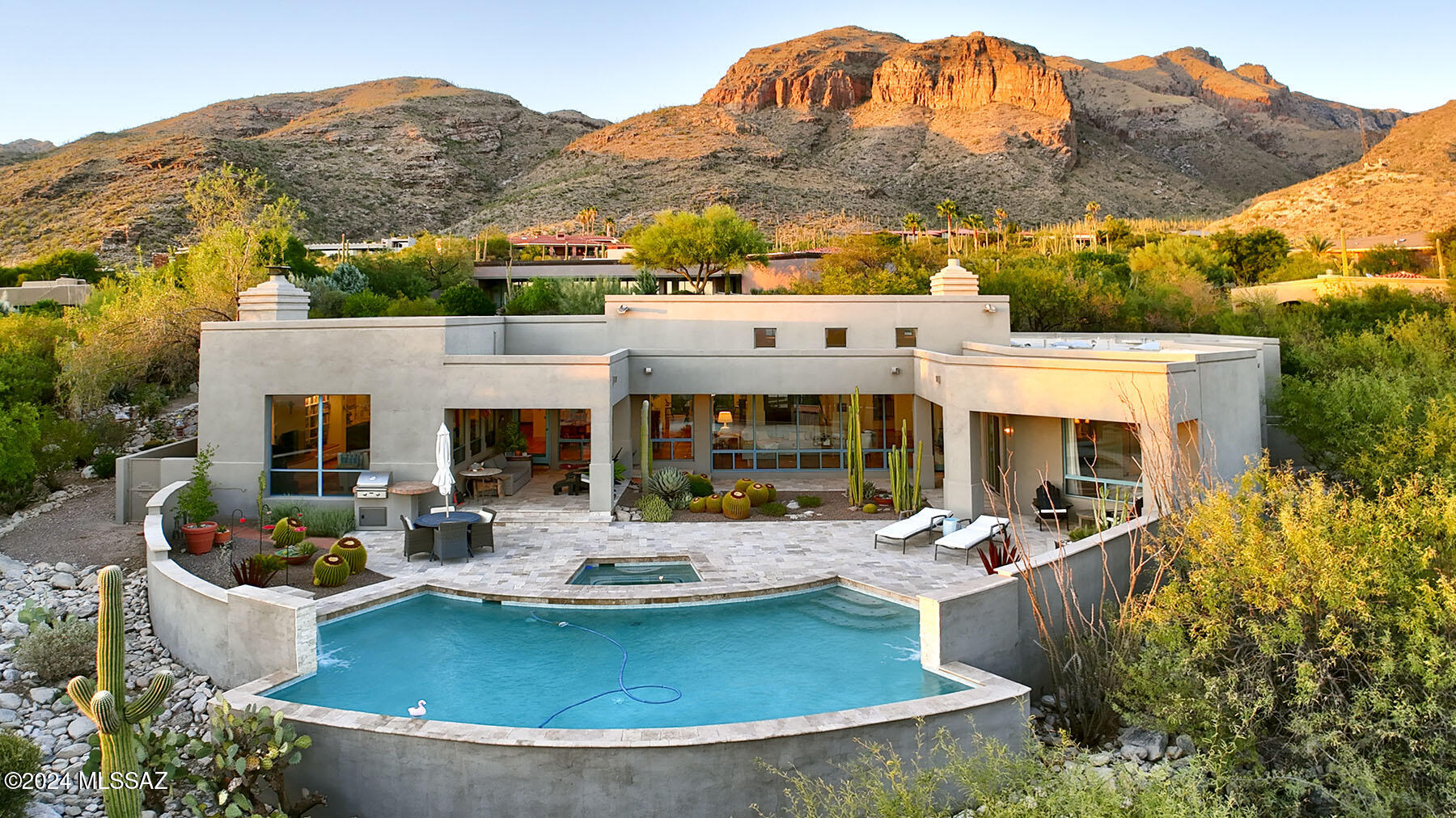 Nestled in the prestigious, guard-gated Cobblestone community, this stunning property offers breathtaking views of the Catalina Mountains and sparkling city lights. A serene natural desert front courtyard, complete with a soothing fountain, greets you as you enter through elegant double glass oiled mahogany doors. The home's open layout invites you to enjoy walls of windows that showcase the beautiful desert landscape, pool, and cityscape. The newly remodeled kitchen by SW Kitchen and Bath exudes contemporary charm, featuring custom alder cabinets with a graystone stain, dual large islands, Miele appliances including an 8-burner cooktop, warming/steamer drawer, Sub-Zero refrigerator, and two refrigerated drawers.The formal dining area offers picturesque mountain views, while the cozy family room boasts beamed ceilings, a fireplace, and built-in bookshelves. The luxurious living room, bathed in natural light, also features a fireplace for added warmth. The primary suite is a true retreat, with a spa-like bathroom featuring a separate tiled shower, a standalone tub, dual vanities, and trendy wallpaper. Ample closet space and stylish guest rooms, including an ensuite, provide comfort for family and guests. Outside, the redone pebble tech pool with water features, travertine surround, and a built-in BBQ offers the perfect setting to relax and entertain while soaking in those amazing views. With a 3-car garage, new Heritage windows, and new carpet throughout, this home is truly one-of-a-kind!