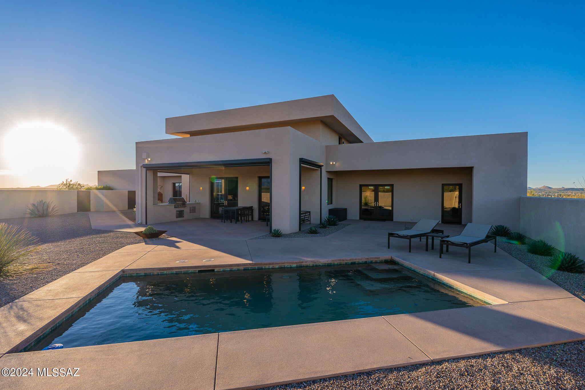 STUNNING MOUNTAIN VIEWS! Peace and privacy--only desert between you and the mountains as you enjoy scenery from the highest point in the area on this outside lot.  Experience this amazing 1.65 acre property with expansive views and all the amenities you could wish for. Beautiful desert landscape greets you as you drive up to this modern contemporary home with an oversized two-car garage and meticulously maintained walkway to a grand covered entry. Step inside to an inviting interior with soaring ceilings, large windows, and glass double doors that let in an abundance of light. The open kitchen boasts plenty of cabinet and counter space, stainless steel appliances, and an island serving the dining area. Take the lighted stairs to an enormous observation deck with so many entertainment and meditation possibilities. The ample primary suite showcases mountain views through double glass doors with easy access to the private patio, a spa-like bathroom with separate vanities, shower, toilet room, and room-size closet to die for! The laundry room has tons of storage, a utility sink, and a separate dog-washing/mop sink. Washer and dryer convey with sale. Step outside to an expansive covered patio with built-in new BBQ leading to a sparkling pool and plenty of lounging areas. The covered patio features electric screens for a comfortable indoor-outdoor experience without bothersome bugs. The backyard is secured with a wall low enough to have unimpeded views while keeping critters out.