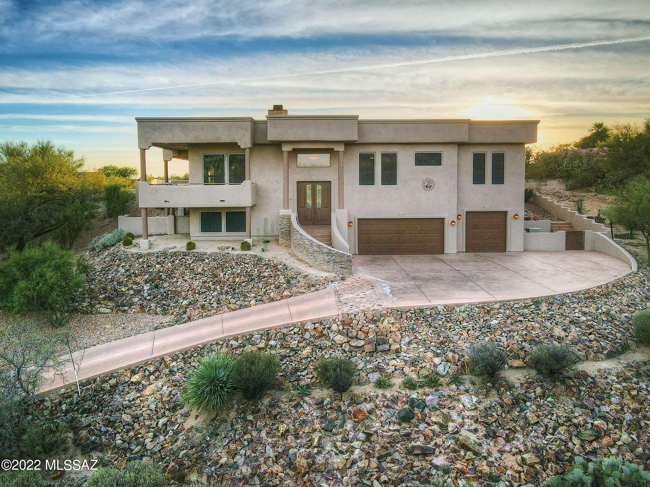 No Driveway Parking/ Street Only! Enjoy an exceptional vantage point to take in panoramic views of the majestic Catalina Mountains, dramatic sunsets, and twinkling city lights from your home perched high on a ridgeline in gated Canada Hills Estates overlooking El Conquistador Golf's 7th fairway! With a sprawling wraparound patio/balcony to optimize views, heated pool and spa with spillway, built-in BBQ, and outdoor fireplace, your private backyard retreat is the perfect place to relax and embrace the outdoors. Inside this dynamic split-level SW contemporary, the home is brimming with sophisticated details including handsome wood beams, graceful archways, and warm wood finishes throughout. Well-appointed gourmet kitchen features stainless KitchenAid appliances including double wall ovens and six-burner gas cooktop a large center island with 3" chiseled edge granite counter, and a built-in beverage center with wet bar sink and beverage cooler. Enjoy the inviting formal dining room with coffered ceiling offers views from every seat! Sure to impress, the expansive great room boasts an abundance of large windows to welcome in natural light and offer framed views of the Catalinas. An adjacent conversation nook with a stacked stone fireplace is the perfect spot to unwind at the end of the day! The spacious owner's suite is a relaxing retreat including an intimate seating area with fireplace and spa-inspired bathroom with frameless walk-in shower, soaking tub, dual vanities, and generous walk-in closet with custom organization. Three additional bedrooms and two full baths offer plenty of space for family or guests. Bonus flex-use space ideal for game room, exercise room, or home office. Adjoining full laundry area with extensive storage and workspace. Oversized three car garage includes an extended workbench corner and extra storage space. Popular Oro Valley Community Center, Naranja and Riverfront Parks, and the Oro Valley Library are just moments away!