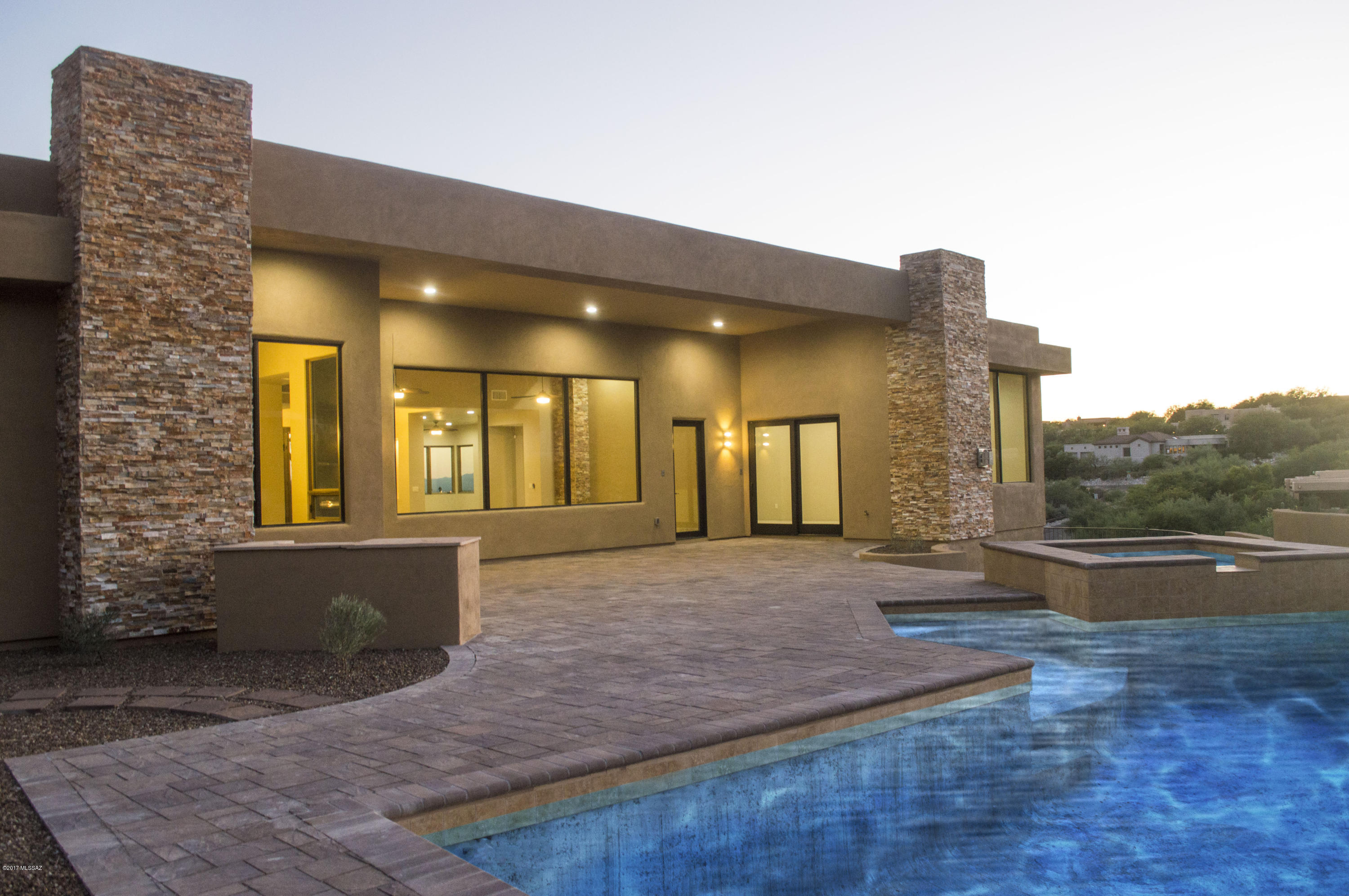 This BRAND NEW 2017 southwestern contemporary home sits high on a hill with a fantastic, unobstructed mountain view and borders natural land in the prestigious Alta Vista. Enter through gorgeous wrought iron custom door into the formal living room with a huge wall of windows, which showcases the most spectacular panoramic views of the Foothills. The desirable layout of this stunning home boasts 4,825 sq. ft. and features a true chef's kitchen with an oversized waterfall island, alder cabinets, top of the line stainless steel appliances, and granite/quartz counters. Additional luxurious appointments include, 8 ft. solid alder doors, Pella windows, 2 FP's, and a freestanding soaking tub. The backyard oasis features a pool, spa and a built-in BBQ.