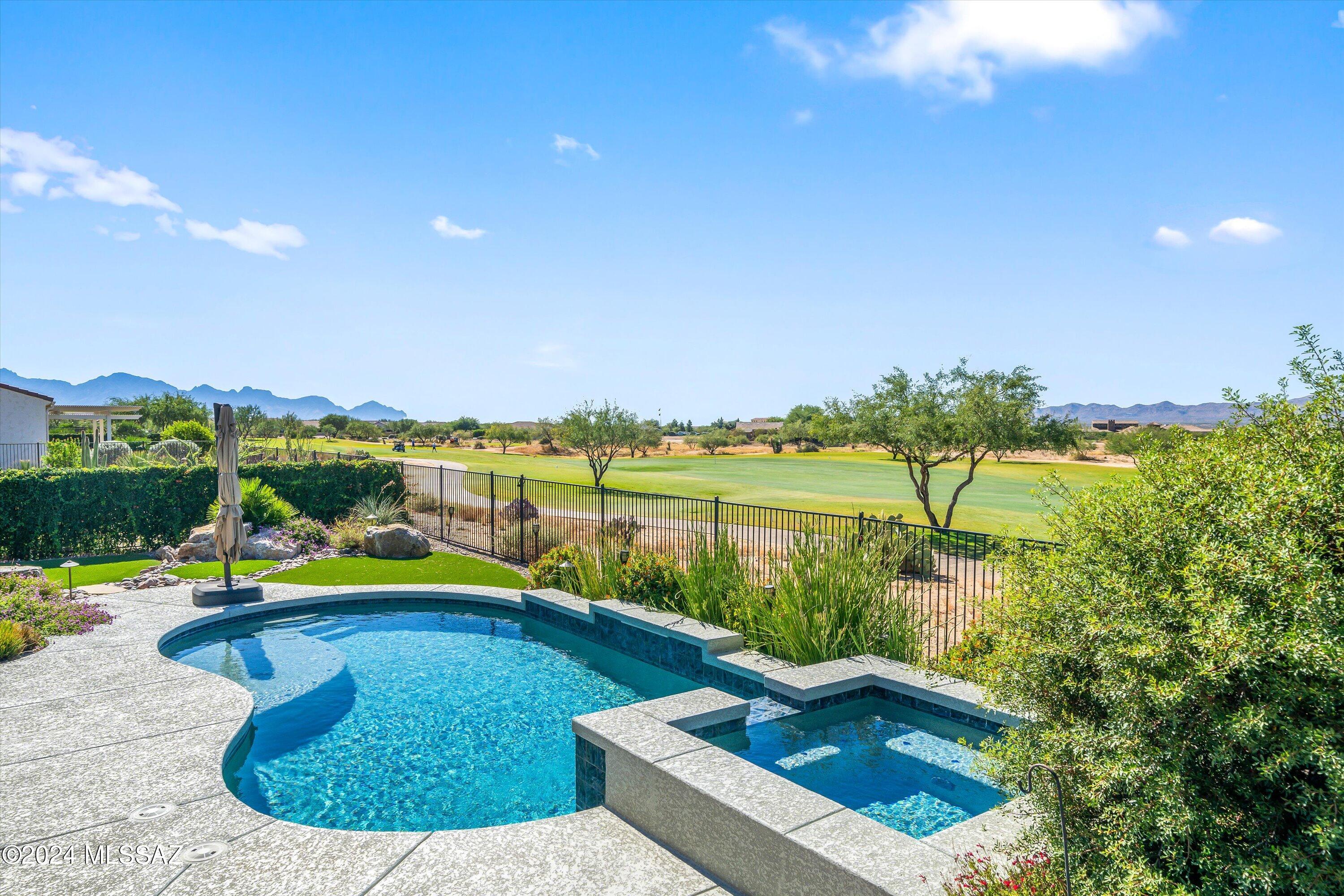 Experience the epitome of luxury living in this sumptuous oasis, where panoramic sunset & mountain views await you. This sought-after Tesoro model allows you to dive into the pristine pool w/ an attached hot tub or unwind on the covered patio, complete w/cozy gas fireplace. Gourmet kitchen boasts a gas cooktop, electric convection oven, upgraded range hood, & elegant kitchen pendants. Entertain w/ease in the Great Room, complemented by the entertainment buffet. Retreat to the primary bedroom w/double vanity, walk-in shower, & two custom closets. Laundry room has upper & lower cabinets & utility sink for added convenience.  Full three-car extended garage w/epoxy floor. This home combines practicality with opulence. Indulge in the lifestyle you've always dreamed of in this exquisite retreat . Absolutely incredible golf course lot with mountain views of both the Tortalita and Catalina ranges!