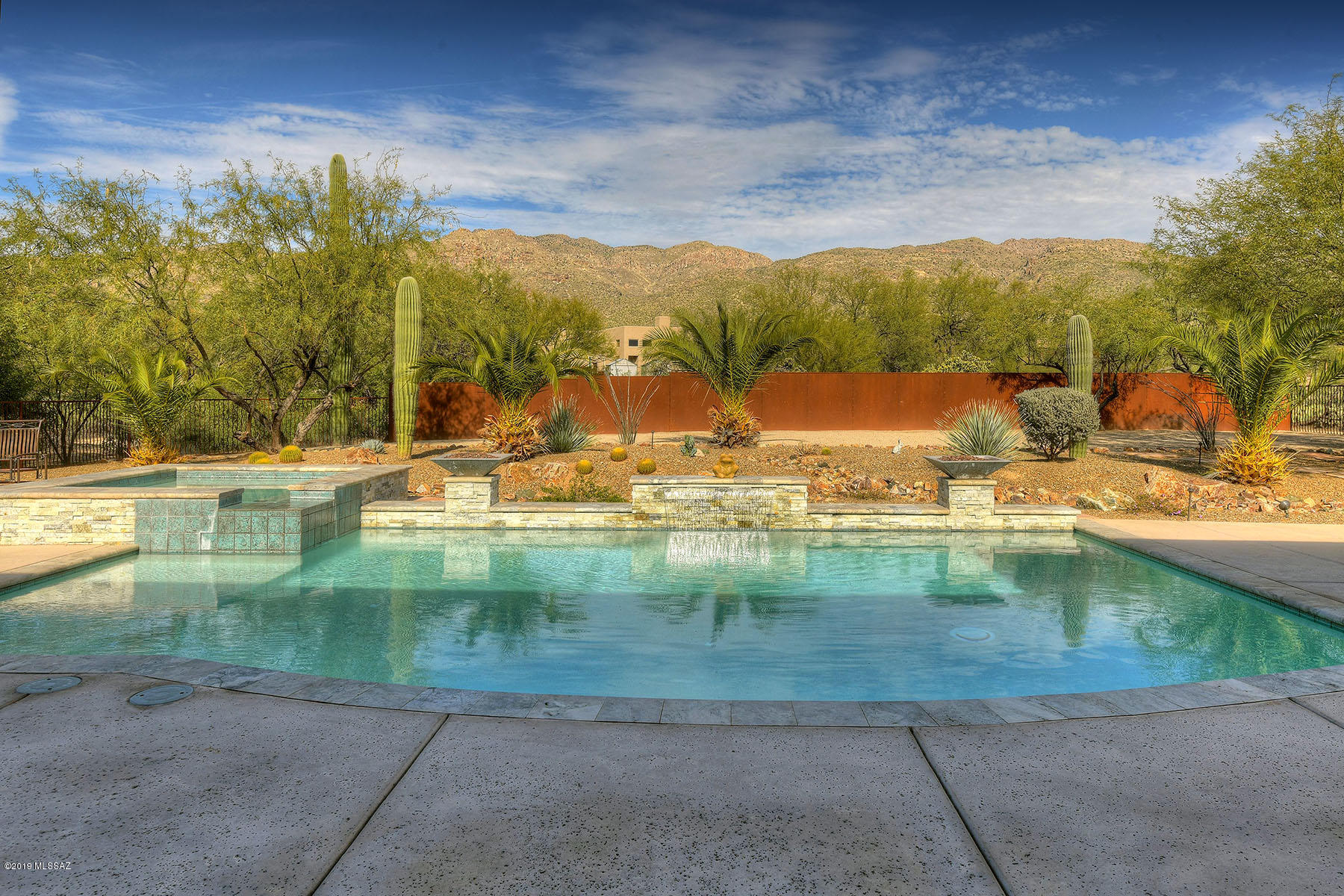 Exquisite Custom Home located in the Tanque Verde Valley. This Luxurious property is located in a small Gated community w/Captivating Mountain Views. Stunning Resort-like backyard Oasis features Pool, Waterfall, Fire features, Spa & Patio areas w/Firepit. Main house offers Bright open floor plan w/12-foot Ceilings and Alder doors. Custom Extra high Windows capture the Majestic Mountain Views from most rooms. This 3826 sq ft home on ~1 acre is a Splendid example of Quality, Style & Design. Deluxe kitchen includes; Granite counters, Upgraded High-end Lighting, Fixtures & Professional grade Appliances. Friends & Family members will love the attached Guest Quarters w/Kitchen, Private Patio, Bedroom, bath & Separate Garage. Save on Utility Costs w/Owned Solar electric. A True Gem!