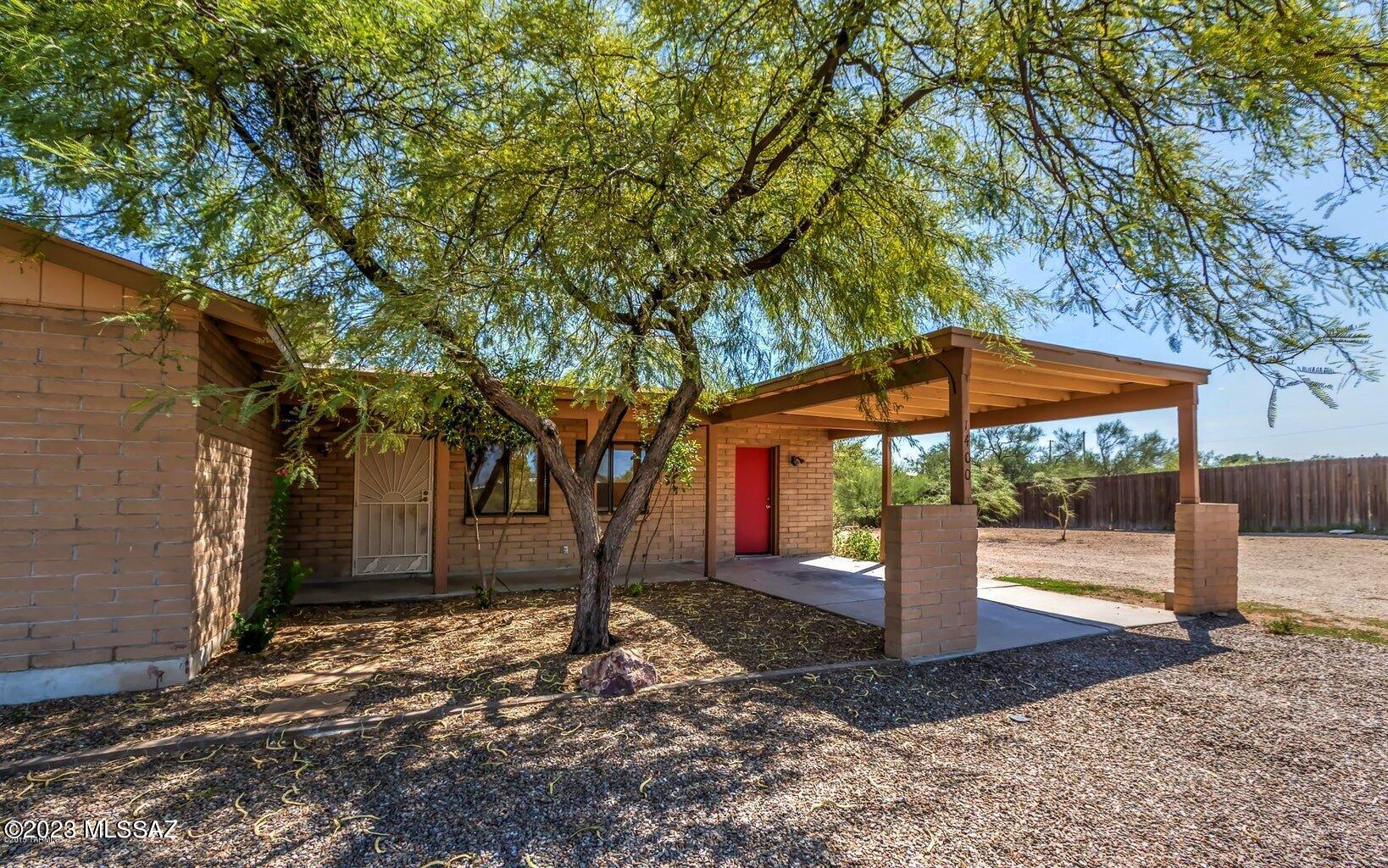 Welcome to New Tucson! Charming 2 Bedroom 2 Bath home that is on over an Acre. Tiled throughout entire Home so no carpet at all. Living room with French doors that open up to a covered porch. Wood burning fireplace in corner of Living room. Separate dining area just off kitchen or use it as the Home office. Large circular driveway and plenty of room to add onto the house, put up a large garage/workshop or put up a guest house. The possibilities are there for you to make it happen.