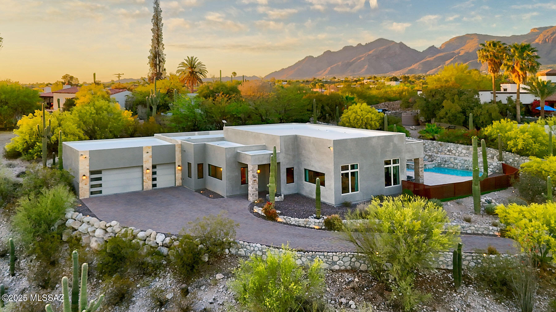 Stunning newer contemporary home on a very secluded 1 acre homesite with city and mountain views in prestigious Catalina  Foothills Estates. A long natural stone lined brick paver driveway invites you into this exceptional home with over  3542 sq.ft., including 4 bedrooms and 4 baths. A professional interior designer, Encantada Designs, created a gracious and cohesive modern look throughout. Exquisite Great Room with dramatic fireplace, high ceilings, walls of windows to capture the views, formal dining room w/multi-tier crystal chandelier and subtle elegant wallpaper, gourmet island kitchen with custom cabinetry, meteor shower granite countertops, breakfast bar, stainless steel appliances, 6 burner gas stove top, beautiful custom backsplash, elegant pendant lighting..... continued..... gorgeous Versailles pattern silver travertine floors, 8ft. Doors, Pella Windows & French Doors, integrated soft colors throughout. Custom floor to ceiling drapes in the living area and black out blinds in the bedrooms and baths. Primary suite with fireplace, 2 large walk in closets, custom pendant lighting, luxurious bath with granite countertops & double vanities, jetted tub, separate shower and private entry to the rear patio. Enjoy the incredible backyard complete with covered patio and stone pillars, travertine tile flooring, gas heated pool, spa and waterfall, artificial turf, lush landscaping, built-in BBQ, wrought iron fencing, dramatic landscape and driveway lighting, 3 car garage with built in storage cabinets, Dist.16 schools, majestic city and mountain views. You will feel like you live in a desert sanctuary yet close to shopping and restaurants. This home is Truly picture perfect !!