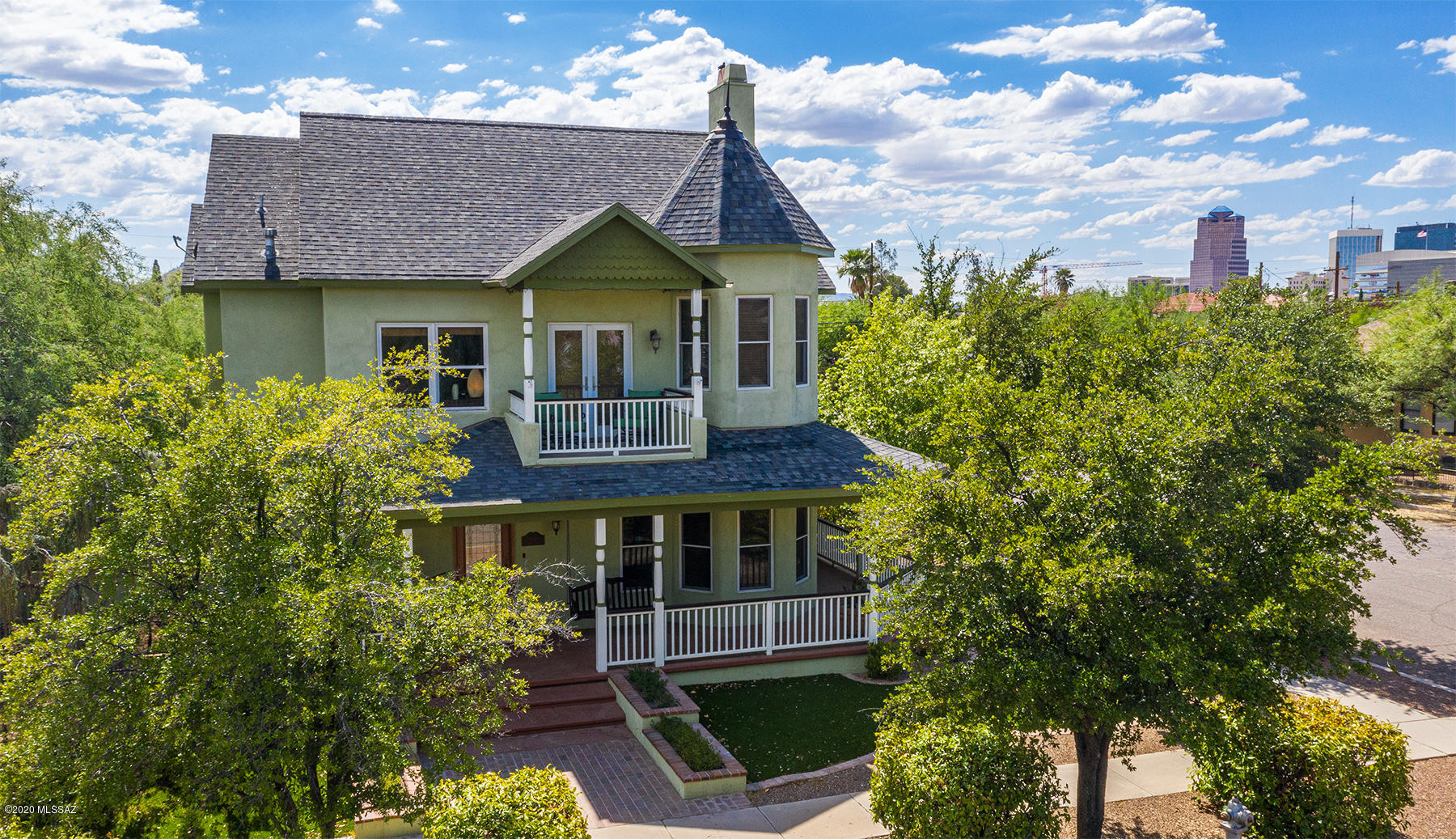 Located on a corner lot in Historic Armory Park. Enjoy  walking to all things downtown.  Built in 2005  w/meticulous attention to detail. History & modern convenience  meld together in stunning custom home. Beautiful great room floorplan, spacious kitchen, new quartz counter-tops. Island, breakfast bar & access to wrap-around porch. Real 3/4'' wood floors & wood case Anderson windows. 2 wood-burning/gas fireplaces, high ceilings, French doors & lots of light. 3BR's + small office/loft off master w/built-in bookcase. Perfect retreat w/mountain & city views, beautiful fireplace, sitting area, private balcony,  bath w/claw-foot tub & sep shower. Guest room w/private bath. Magical, private, hidden yard, built-in BBQ, fountain, mature trees & low care turf. Plus hard to find 2 car garage!