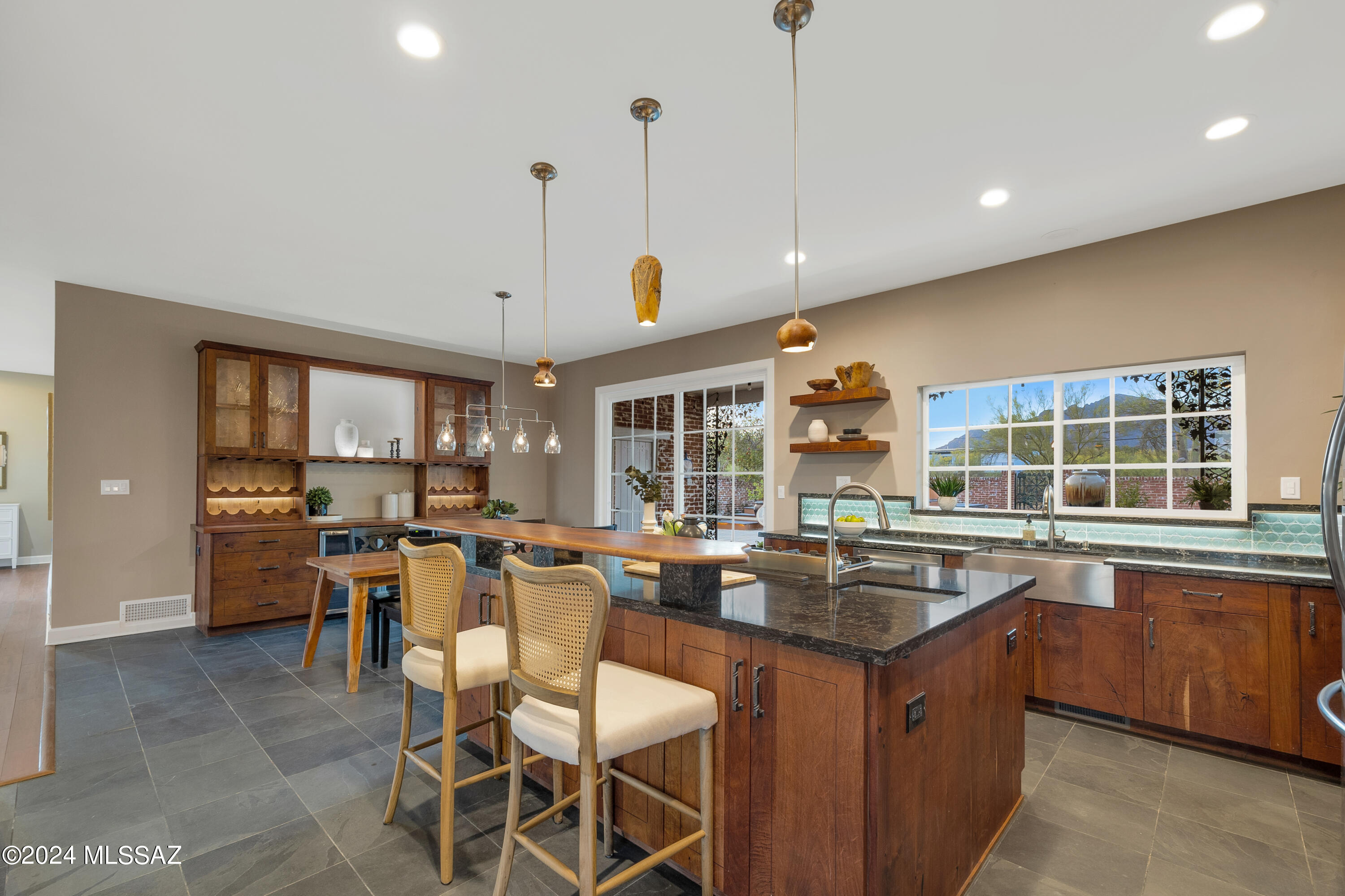Nestled in the Catalina foothills, this classic home bestows a sense of peace & privacy while every room is infused with light and views.  Bring your ideas for a Casita or second garage/workshop.  There is plenty of room to expand on this 1.14 acre view lot. The chef's kitchen features mesquite cabinets, Cambria quartz counters & a large island. The dining room is a host's delight with built-in bar. Designed for entertaining, the expansive Great Room provide space for a pool table, large screen TV while creating a seamless flow from other areas so all can enjoy gathering around the fireplace and enjoying the city lights. The generous primary boasts a renovated bath.  Seller is licensed AZ real estate agent Two additional  large bedrooms share a Jack & Jill bath. All bedrooms & the living room feature bamboo floors while the kitchen, family, dining & powder rooms feature slate floors.