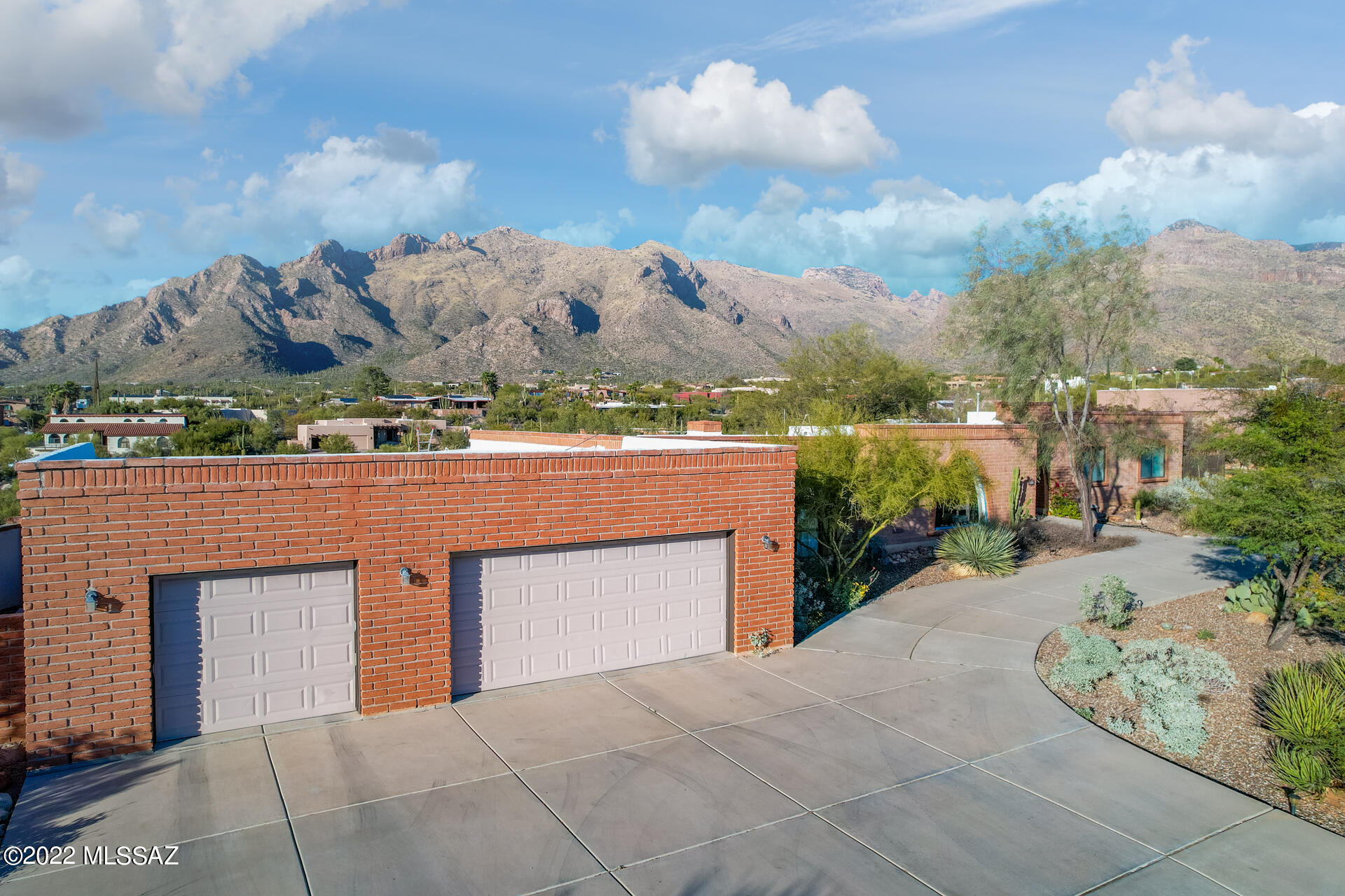 Beautiful Hilltop, burnt adobe, mid-century ranch home in sought after Catalina Foothills neighborhood with easy access to restaurants, shopping, schools and walking trails. 4 bedrooms with 1 offering a private entrance, 2.5 bath, 3 car garage and newly remodeled kitchen. At the heart of the home; kitchen, breakfast area and den with stone fireplace, offers stunning mountain views and a sense of indoor/outdoor living. Large, inviting sun filled bonus room with built in bookcases, sparks the imagination as a music/artist studio, gym, MIL/guest suite, movie room or remote office. Spectacular Mountain views encircle the private pool area with covered patio and backyard oasis with natural vegetation.  A home for those craving nature and serenity while being in the center of it all.