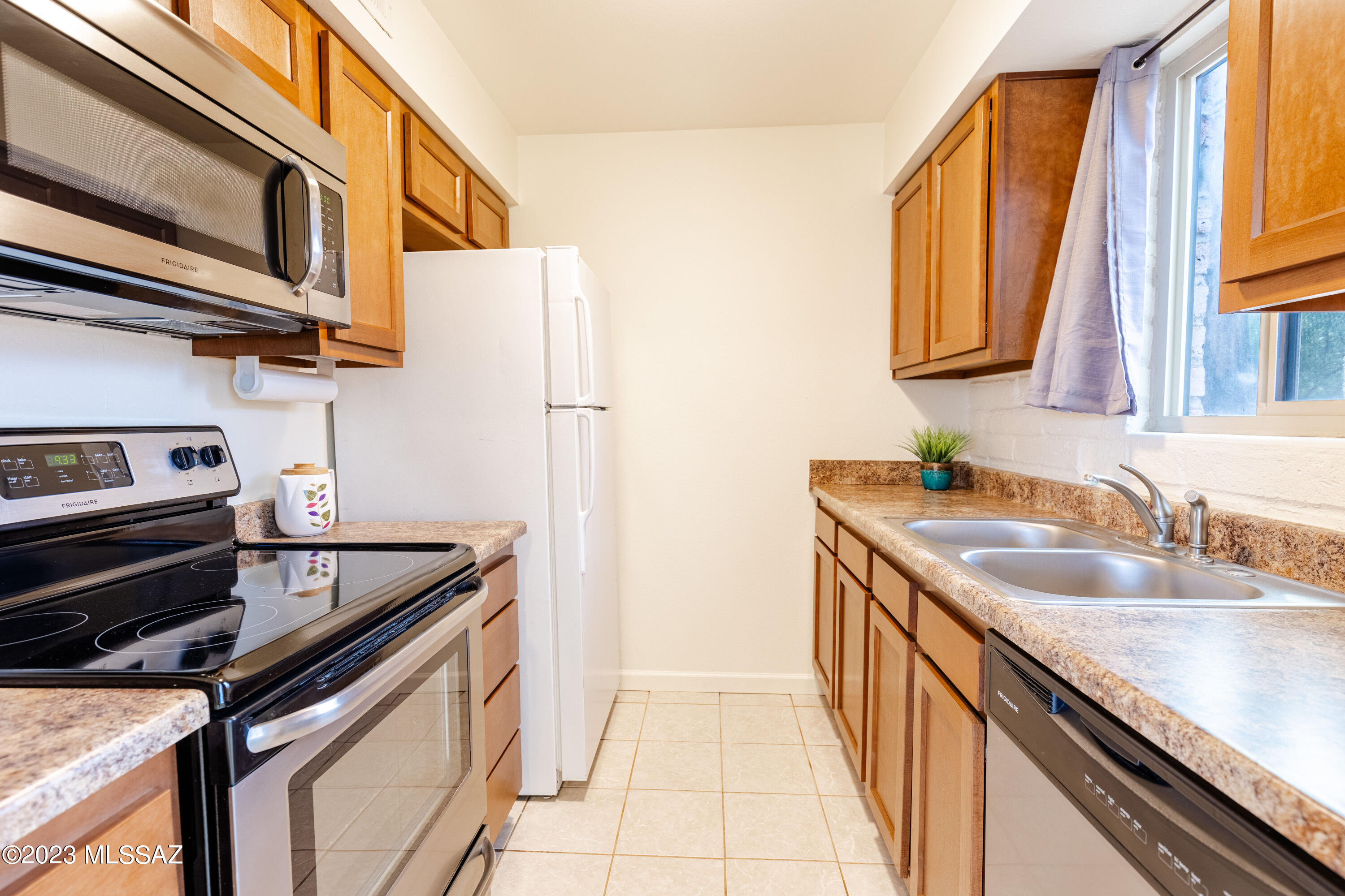 This move-in ready second level D condo in the Meadows has all of its living space on one floor and features updated dual pane windows, maple kitchen cabinets, stainless steel appliances with included white refrigerator, and no popcorn ceiling. Enjoy some Catalina Mountain peak views from the bedrooms & family room. There's ample storage space within the unit and additional storage in the carport below.  The Meadow is a lovely community amongst grass and large mature trees with two neighborhood pools, quick access to the Loop Path and the numerous businesses near Tanque Verde & Kolb/Grant.  The HOA fee includes water, trash, roof, exterior maintenance of the unit, water heater, laundry facilities, and more.  It's a perfect property if you're looking for low maintenance and convenience.
