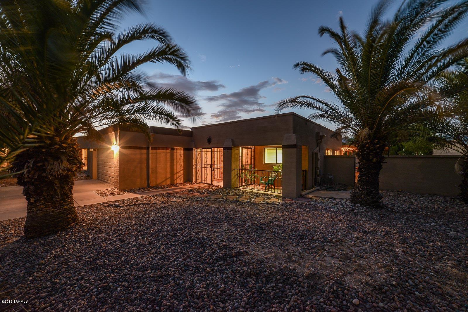 Pride of ownership, spacious, lovely home on a choice 9600 + SF lot that backs up to a riparian area by a natural preserve. Mountain & sunset views. Beautifully tiled & carpeted, the home has an eat-in kitchen with lots of counter space, a fireplace serving both the living rm & the den, walk-in closets in each of the large bedrooms, plus a full MBR wall of closet. 6 ceiling fans inside & 2 on the oversized east patio, overlooking low care wildflowers & a butterfly garden. That patio is another room, just outside. At night, listen to the owls & coyotes in the mesquite bosque that also has cottonwoods & black walnut trees. A short walk to the community pool & jogging trail. New water heater, new garage door opener, & roof re-coated within last year. Both refrigerators stay