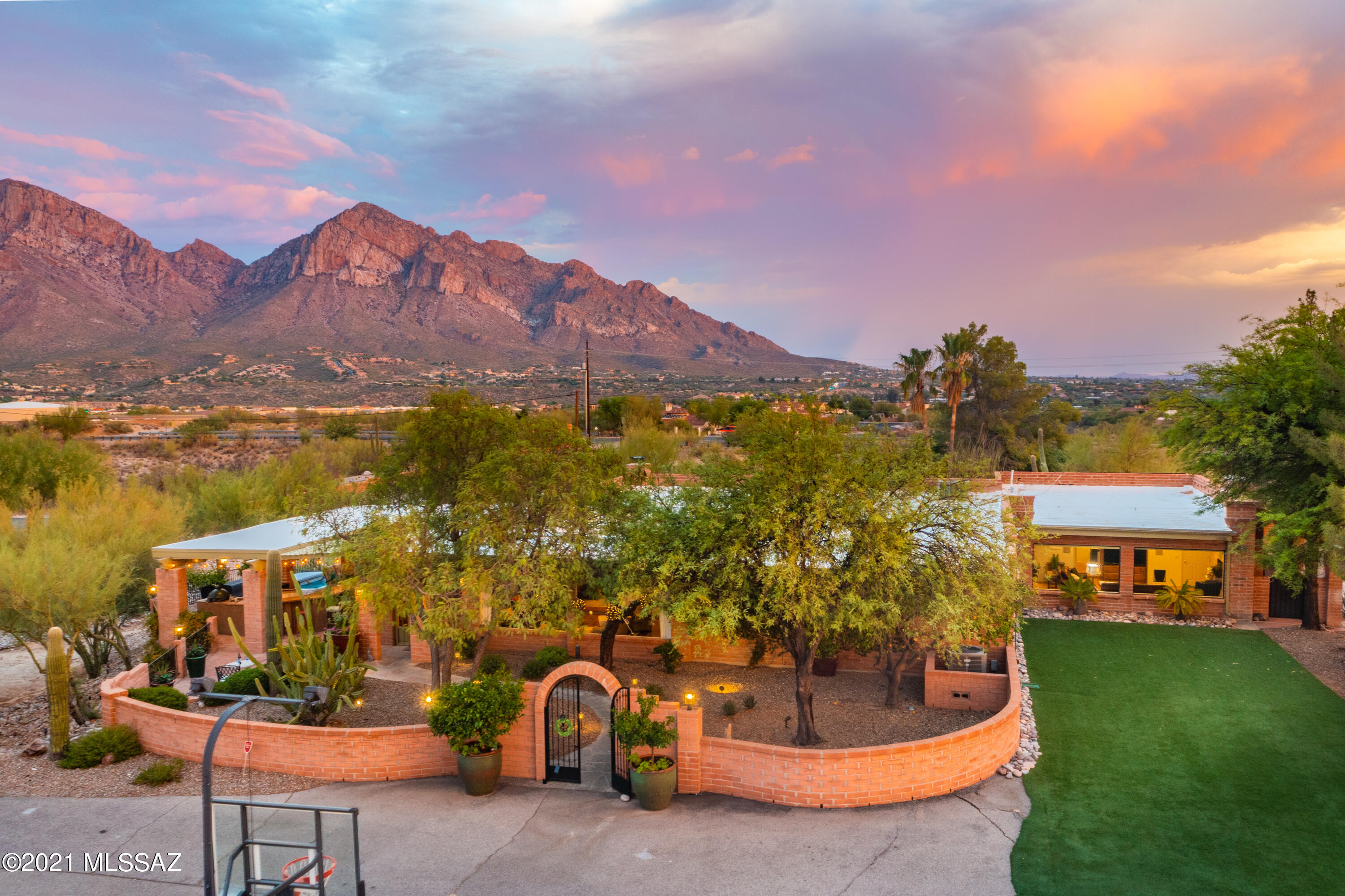 Old World Charm in the heart of Oro Valley with breathtaking mountain views! If you are looking for the epitome in classic Tucson living, then don't miss out on this sprawling 3285 sf single story 4 bed/2 bath burnt adobe hacienda that includes an 864 sf 1 bed/1 bath separate guest house as well as a freestanding 4- car garage on 3.41 acres. Situated perfectly to take in the views and create a private, tranquil oasis, this home boasts an inviting courtyard which leads into a large sunlit living room which then guides you through the gorgeous updated chef's kitchen complete with custom fireplace and all the bells and whistles you could want. There is ample space for the entire family indoors, and the outdoor living space is simply divine. From the custom outdoor kitchen, to the covered porches and patios, to the viewing deck and negative edge pool...you cannot miss the VIEWS. This property must be seen in person to appreciate all it has to offer.