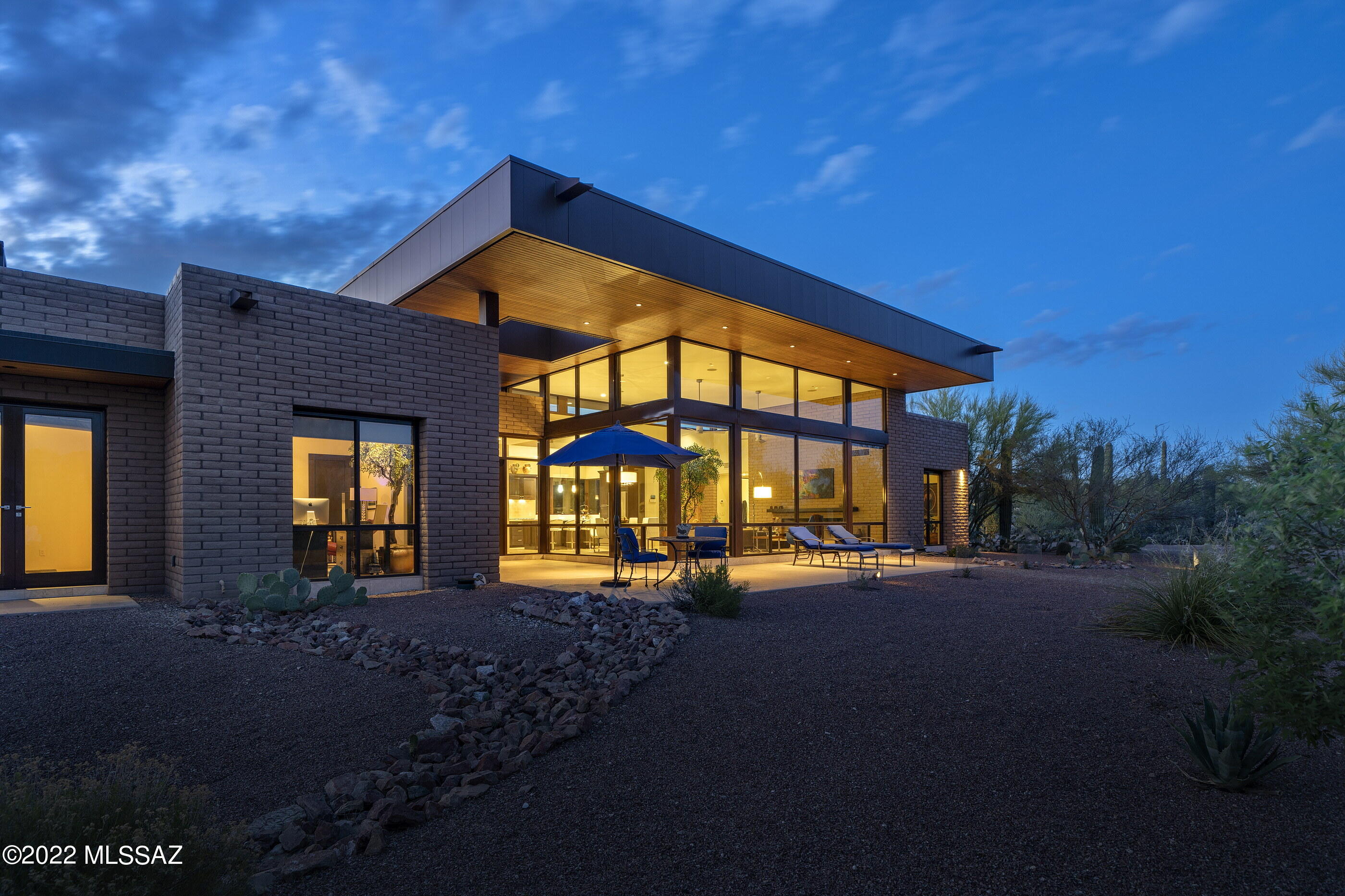 Built in 2013, this Robinette desert contemporary is the ultimate lock & leave AZ residence. Ideal property for pilots, equestrians, or anyone seeking a peaceful, sanctuary-style setting w/ extraordinary views & abundant wildlife. This privately gated home is located on an 8.42-acre saguaro-studded mountain view lot w/ unmatched privacy in the La Cholla Airpark- a private residential airpark in the foothills of the Tortolitas. A long, exposed aggregate driveway surrounded by natural desert leads to this striking custom home built w/ concrete block, walls of glass, metal & wood & offers a contemporary design that effortlessly brings the outside indoors. Have all of the luxuries & amenities expected without the maintenance & upkeep of a large home. Efficient 2800 SF,  2-bedroom/2-ba CONT... home with an open, split bedroom floor plan & oversized 3-car garage with a mini-split for temperature control.  Great room with soaring ceilings, an impressive concrete block gas fireplace & walls of windows that channel natural light & capture glorious views of the Catalina Mountains & the surrounding natural desert. Magnificent kitchen with a center island & breakfast bar.  Custom cabinets, Silestone countertops, stainless steel appliances including gas cooktop, & walk-in pantry. The corner window at the kitchen sink captures scenes of the desert outside. The formal dining area in the great room is adjacent to the kitchen. A sizable master suite with a see-through fireplace has a bonus area that can be used for an office or any needed use.  Oversized master bathroom with custom dual sink vanity, shower with one of a kind tub with lights, music, aromatherapy, jets & bubbles.  Spacious shower with floor to ceiling tile with glass door that leads to private, walled yard space with an outdoor shower, artificial turf & stairs to the rooftop deck. Enjoy sunsets that paint the sky with vibrant colors and starry nights from the rooftop deck. Huge master closet that would typically be found in a much larger home with custom built-ins.  Adjacent to the master bedroom is a bonus room currently used as a dedicated massage room.  On the other side of the home is a private guest bedroom & a large full bath with tile surround shower . The laundry room with custom cabinets & storage leads to an oversized 3-car garage with a sink,  temperature control, epoxy floors & allows for multiple uses or storage opportunities. The current owner is using overflow space for an exercise area. Other features include a tankless water heater & a propane tank installed to fire gas appliances & fireplaces.  Superb northwest Tucson location convenient to the Stone Canyon Golf Club- a world-class country club w/ tennis, pickle-ball, fitness & social events in addition to golf.  
La Cholla Airpark Information:
At La Cholla Airpark, residents live with their planes, horses, and abundant wildlife around a 4500-foot paved and lighted runway. The Airpark is 20 miles northwest of Tucson, AZ, and set on 1.5 sections, or about 1000 acres. All lots are a minimum of 7 acres.
La Cholla Airpark is a private residential airpark. The runway is for the use of residents and their guests. Transient aircraft are welcome on prior permission only basis. 
Our large lots afford us a rural lifestyle, including horses, with shopping and schools nearby. Wildlife is abundant, with frequent sightings of Deer, Javelina, and Harris Hawks to name a few.
Nearby Stone Canyon Club Information:
Stone Canyon is a hidden gem nestled against the picturesque Tortolita Mountains in the town of Oro Valley, just northwest of Tucson, Arizona. This private golf community boasts over 1,400 acres of breathtaking land and is highlighted by a Jay Morrish designed world-class golf course. Stone Canyon is the only golf course in the greater Tucson area ever to be ranked in the top 100 golf courses in America according to Golf Digest. Accompanied by a luxurious Health & Fitness facility and a modern restaurant, Stone Canyon leaves no stone unturned in providing you with all the comforts one could desire. Enjoy our many golf, social, and fitness events hosted consistently throughout the year.
 
 In early 2016, our newly designed Clubhouse was opened. The 25,000 SF complex features a men's and women's locker room, golf shop, dining room, indoor bar, outdoor bar with a fire pit, along with ample outdoor covered seating. Situated directly behind the 18th green, the Clubhouse provides 270 degrees of amazing views. Whether it's looking back up the 18th fairway or taking in the majestic Santa Catalina Mountains at sunset, the Stone Canyon Clubhouse is the perfect setting for post-round cocktails or dinner with friends and family.
