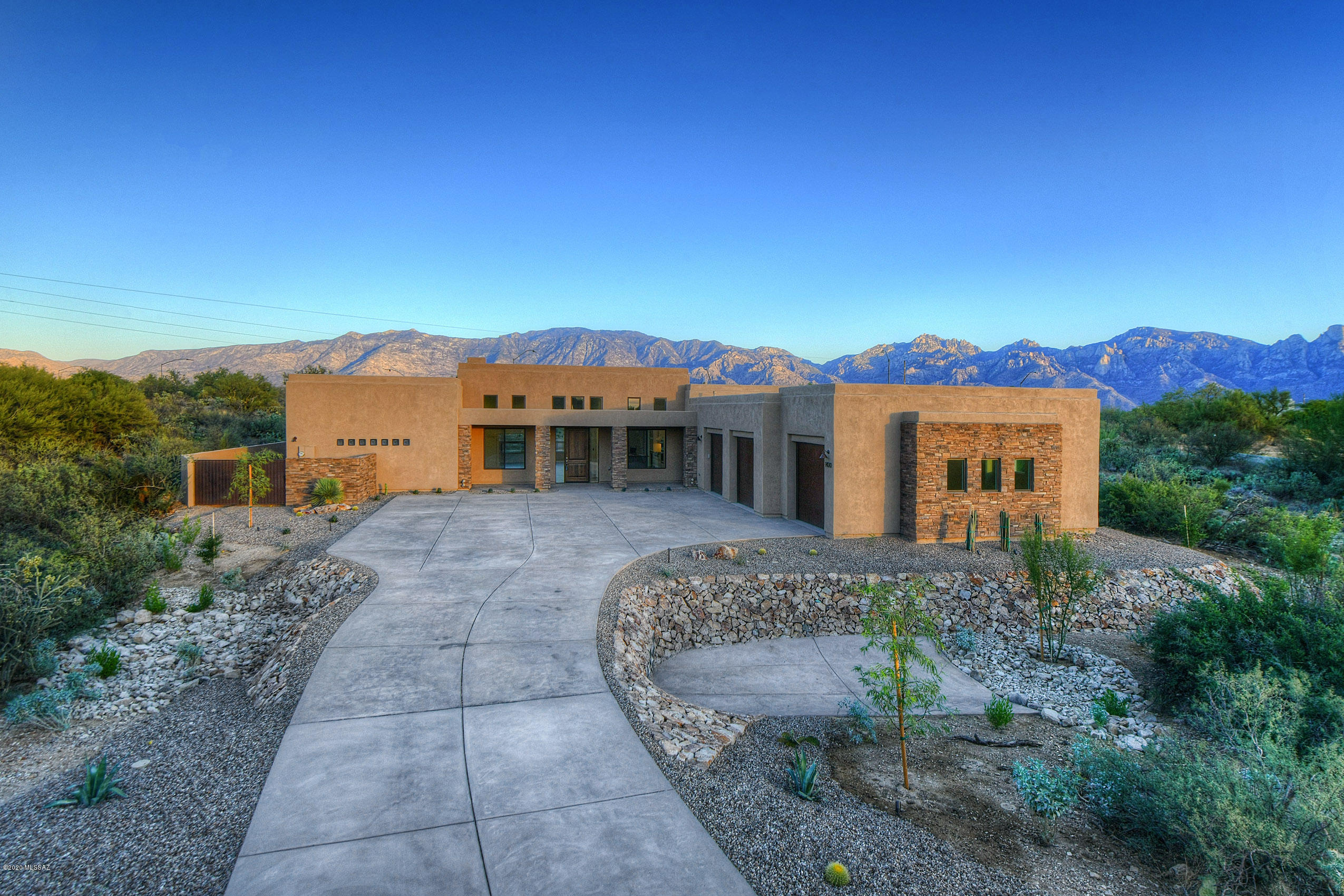 Welcome to Honey Bee Ridge, Oro Valley's
 premier guard gated community. Walls of windows capture the breathtaking views from this newly constructed  contemporary home. Light and bright with high ceilings, gorgeous greatroom with a fireplace and a wall of windows with the mountains as your backdrop. Fabulous kitchen with a dining area and island, lots of cabinets and storage with a walk-in pantry. Split bedroom plan, large master closet with spacious bath and beautiful quartz vanity. Wood tile in the living areas with carpeted bedrooms and office. Huge 3 car garage with plenty of extra space for a work shop or gym. Back yard is all ready for you to create your own dream. Equipped with a pool in mind as well as a drip system, built in BBQ. This won't last!!