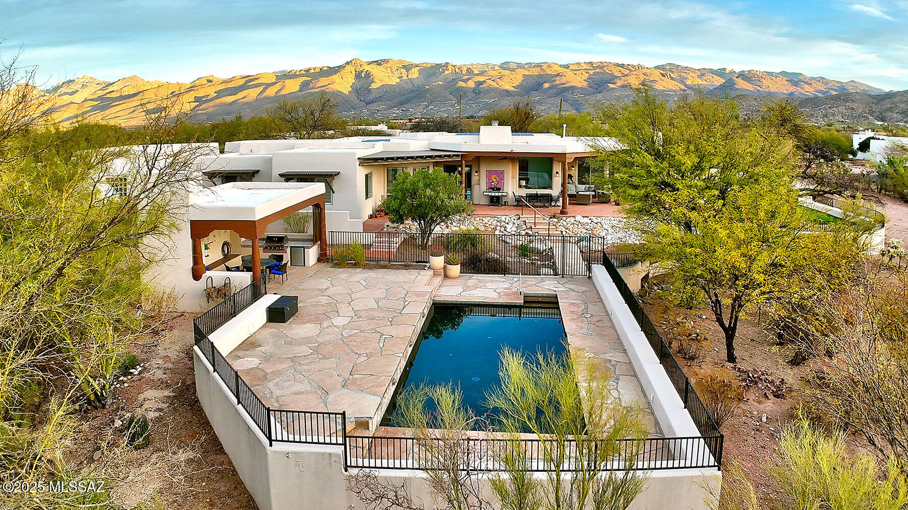 Exquisite Sante Fe property w an open floor plan. The great room features high ceilings filled w natural light, providing panoramic mountain views of the Rincon & Catallina Mts. Split floor plan w a primary suite, a beehive fireplace, luxurious spa bath & a private patio entry. Generously sized guest bdrms w plantation shutters &  storage. Kitchen, baths & laundry have been  exquisitely updated. Tranquil outdoor living w brick pavers, covered patio, saltwater, heated pool  w covered  ramada, plus outdoor kitchen, fireplace & flagstone pavers. Enjoy the sunrise from private backyard. w natural surroundings.  Pristine home w exceptional design & lovely VIEWS. Owned solar. Located on a cul-de-sac  w a 4- car garage!  Tanque Verde schools. See documents for many upgrades