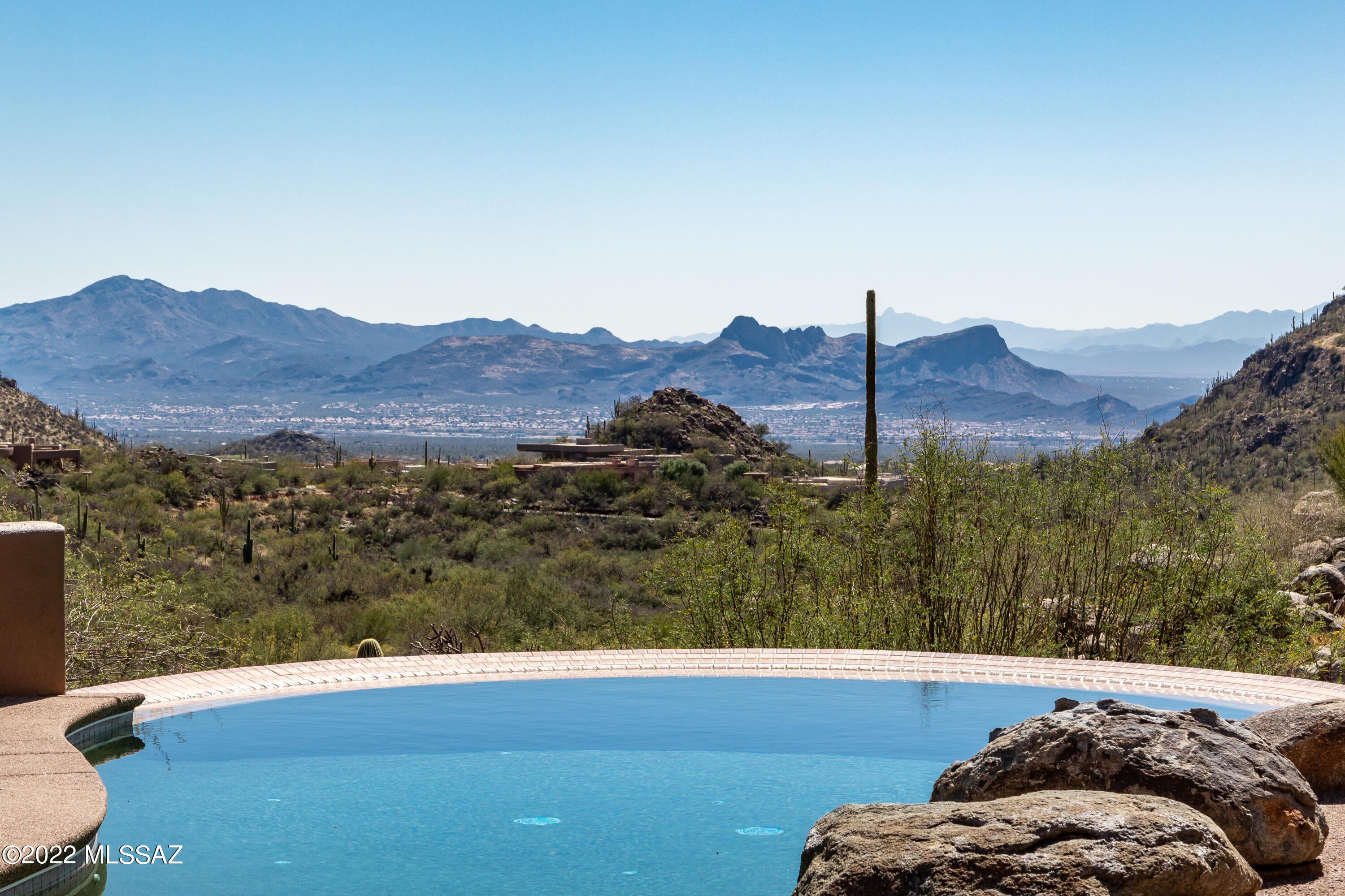 WOW !!!  When architect Ron Robinette and interior designer Lori Carroll team up they created a house that is a home with desert and sky.  With breathtaking views, you will be mesmerized as you look at the panoramic vista  towards the Tortolita Mountains and a setting that is so magnificent!  With a WATERFALL capturing the views of the canyon walls from one side and POOL and SPA capitalizing views of the Tortolita Mountains from the other ! This open concept features two bedrooms with a extra room that could be used as a 3rd.  Master bedroom has a fireplace and the use of glass heightens the effect of an indoor/outdoor experience. Master has a enormous walk-in closet. The foyer flows into the Dining Room and the Great Room that embraces the outdoors through sliding doors with transoms that stretch the views almost to the ceiling. This home has a guest suite that overlooks the summer patio and waterfall.  With many extras , such as subzero refrigerator, two stainless steel ovens and warming oven, built-in desks in office, outside fireplace overlooking the pool and three car garage and much more. With the floorplan shaped this house to the round contours with a circle design creates a sense of privacy by focusing on all the views, no wonder Home and Garden Magazine did a eight page spread of this extraordinary home !!!