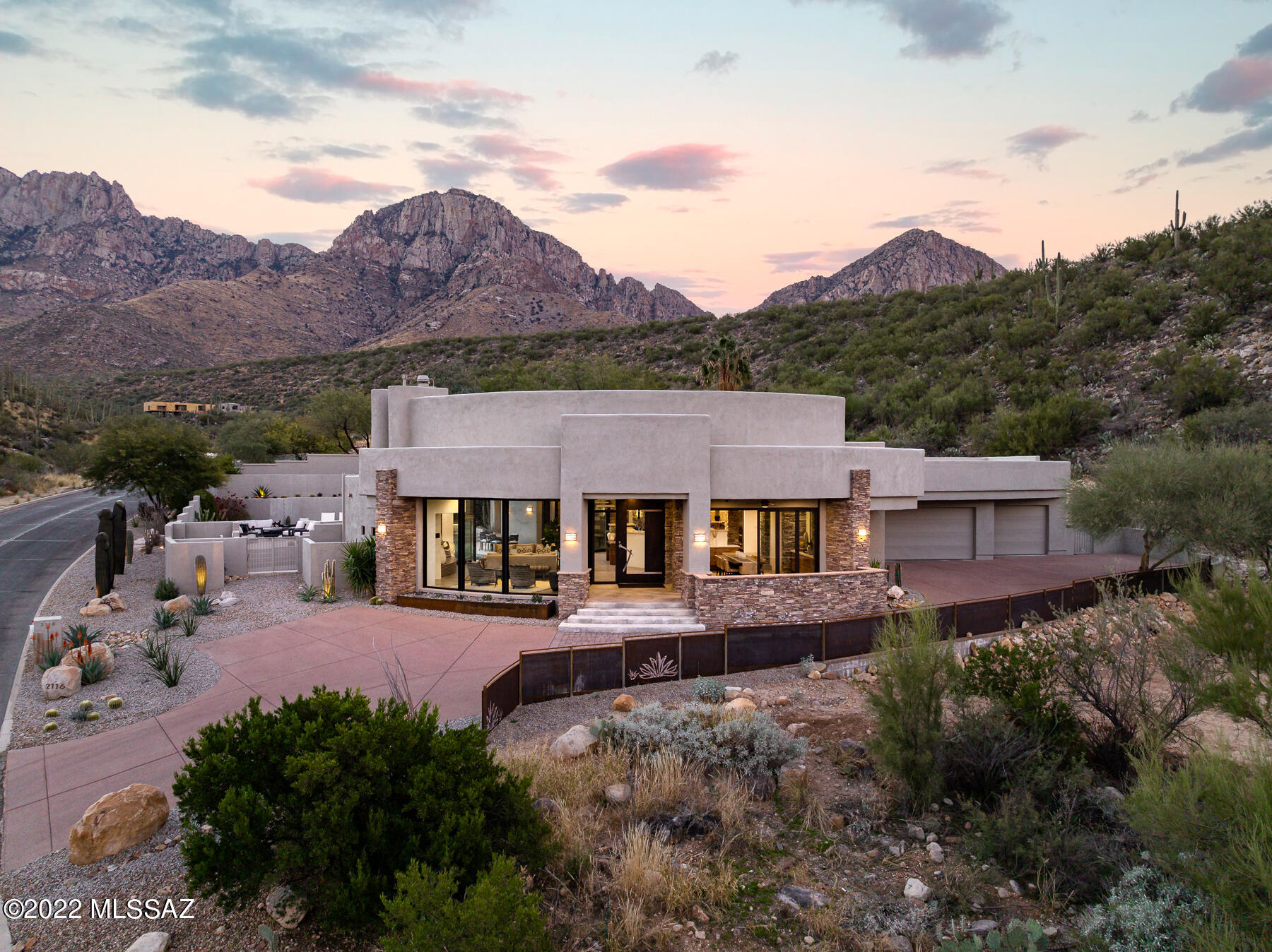 Exceptional desert contemporary custom home located on a pristine over 3-acre lot in sought-after guard gated La Reserve in Oro Valley. This elevated homesite delivers extraordinary views & privacy coupled w/ thoughtful design & flawless execution for the ultimate in desert living. 3 bed + office, 3 bath home. Major interior renovation completed by the current owner has taken this 2006 home to next level. Upon entry you are greeted by walls of windows that flood the space w/ natural light & capture impressive mountain & city views. The flat-screen TV descends from the ceiling above the great room DaVinci fireplace, providing space to display art when TV is not in use.  Bright & spacious, modern kitchen w/ custom cabinetry, quartz countertops, large center island w/ dbl sink MORE prep sink w/ disposal, 2 breakfast bars, Wolf, Viking & Sub-Zero SS appliances opens to the great room for ease of entertaining & enjoying time w/ friends & family. Large walk-in pantry w/ SS wine cooler & additional refrigerator. Formal dining room w/ built-in buffet & spectacular city views. Massive retractable glass doors w/interior & exterior automatic shades lead to resort-style backyard w/ pool, spa, waterfall & unobstructed views of the Pusch Ridge & seating areas w/ city views.  Effortless indoor/outdoor living for gatherings small & large. 
Split bedroom floor plan has an impressive master suite w/ office area, truly luxurious spa-inspired master bath w/ modern soaking tub, separate shower, his & hers closets w/ custom cabinetry. 
Guest bedroom wing has a private en-suite guest bedroom w/ upgraded bath & 3rd bedroom currently being used as a work-out room. Versatile additional bathroom is ideally located for pool use and guests.  Large separate yard area w/ desert landscape & turf. Exterior finishes merge together stacked stone, metal & glass to compliment the surroundings. Oversized 1069 sf 3-car garage w/ sink & storage. For those looking for privacy and serenity & very close proximity to the best shopping, restaurants, world-class golf resorts, hiking, biking & the aquatic center in the Oro Valley area, this location is unrivaled.