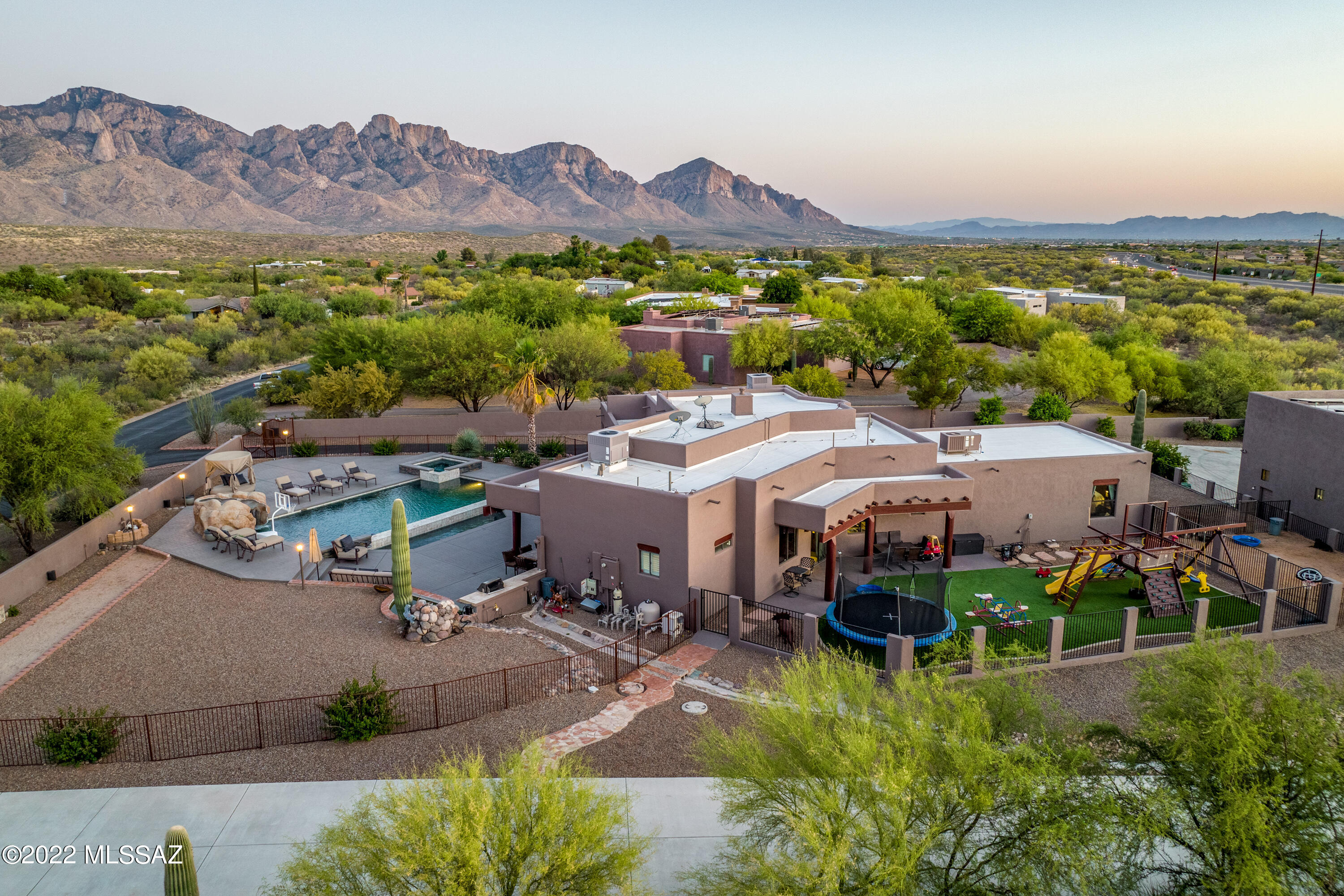 The highly desired expansive Catalina Mountain view poolside is here and on the market! Huge outdoor living space with multiple terraces perfect for entertaining.  Newly pebble tec'd pool with large spa and water fall, outdoor BBQ, kids play area and a massive extra tall 9 Car Garage for the toy enthusiast!  Car lift to convey. Room for cars, boats, RV (Electrical Hook up Available in Garage) UTVs, etc. you name it... you have the space to keep it all nicely enclosed.  Garage has access on both ends for easy access in and out. NO HOA yet located in a neighborhood with well maintained homes and paved road.  Dual gated entrance into your new home fully walled in for maximum privacy.  Oversized luxurious primary suite with walk-in closets including sit down vanity and large shower. You'll appreciate the space offering 2 master suites and 3 additional bedrooms or convert one into an office space.  Appreciate this absolutely perfect location just minutes north of Oro Valley for the country living feel with access to many riding trails and hiking as well as being minutes away from all major shopping.