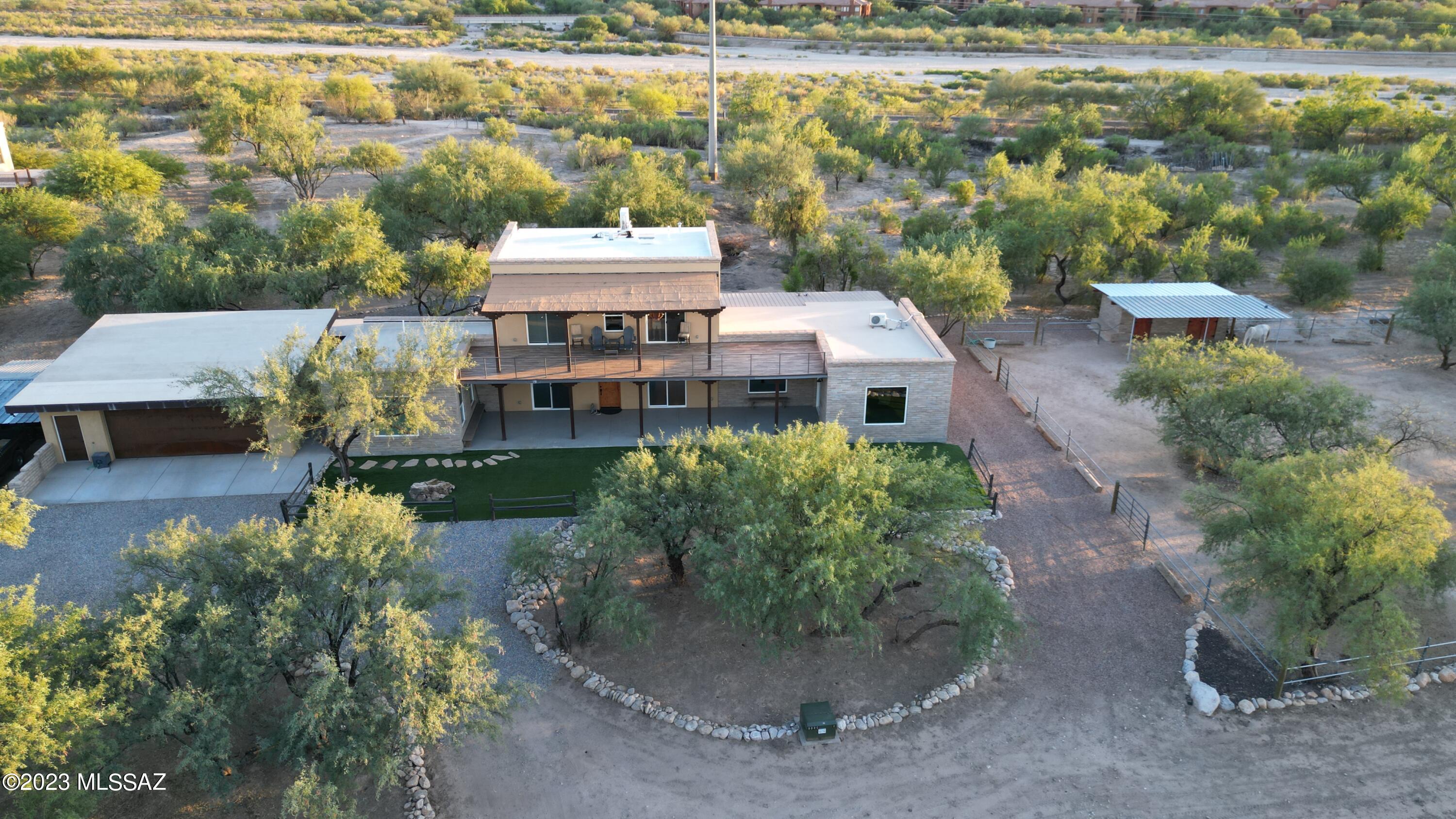 Immerse yourself in tranquil rural living at this authentic 2020 Southwestern adobe home with stunning mountain views on 2 and a half acres of lush riparian land. Inside, you'll find three bright bedrooms with custom walk-in closets and 2.5 bathrooms. The 3,700 sq ft space features a modern kitchen with ample storage and new appliances, as well as spacious covered patios facing north and south. Nestled in a serene countryside, this property offers peaceful living with easy access to downtown and the University area. Connect to the Rillito loop for outdoor activities. Horse enthusiasts will appreciate the shared facilities, which include an arena, shade structure, and an adobe tack room with a hay barn. The 2.5-car garage has a workbench and ample storage. See it today!