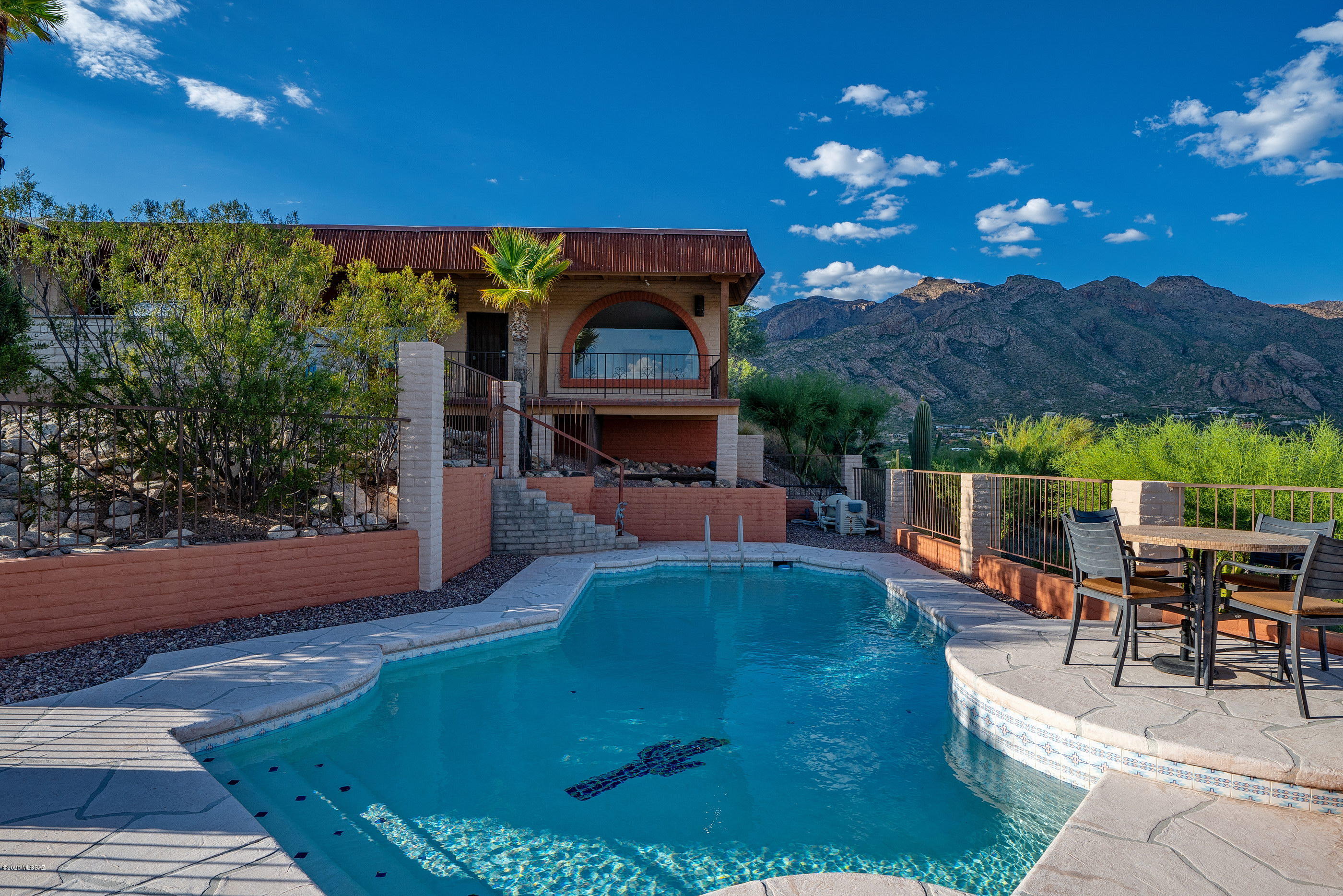 Enjoy some of the most dramatic Mountain and expansive City views from this privately situated hilltop residence. Sited on 1.1  pristine acres, offers spectacular sunset and city lights, easily accessible through the picture windows strategically placed to enhance the many view corridors. Quietly tucked away on your own private meandering drive, this bright and airy floor plan provides for open comfortable living spaces. A breezeway acts as the main point of entry, opening onto the primary public spaces, with the master suite sequestered on the Southeast end of the property with dramatic picture windows, while the two remaining secondary suites are secluded on the North ends of the residence respectively. The open kitchen concept flanks the formal living, dining and family rooms.... with stunning exposed wood beamed ceilings adding to the dramatic scale and space. This home is move-in ready, great for families, or those looking for a little extra space. A succession of private outdoor spaces offer different elements, such as a resort like pool on the East end of the property, as well as the South facing veranda and North facing private rear yard. Close to shopping, golf, fine and casual dining, hiking/biking trails, schools and the world class resort/spa - La Paloma Country Club.