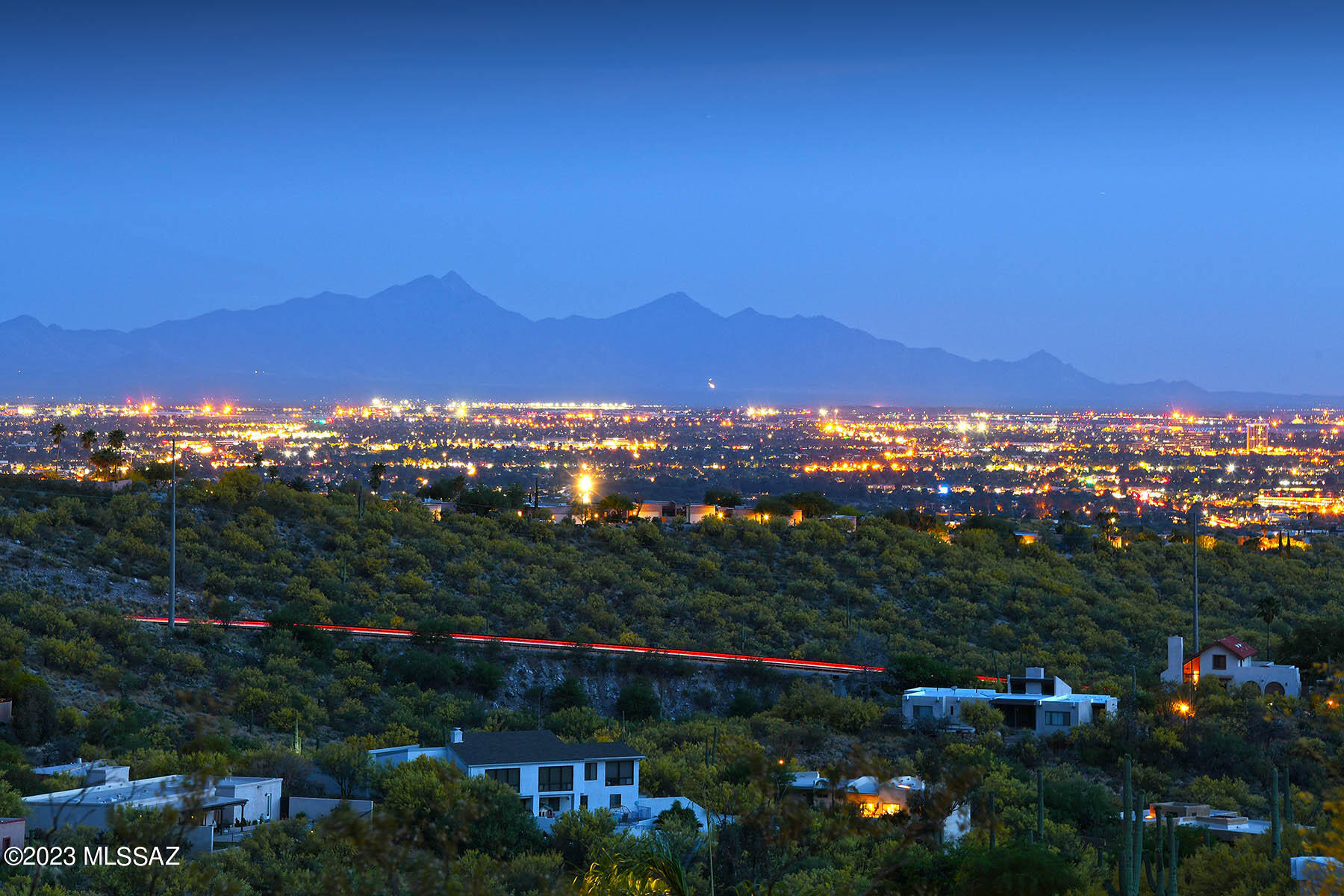 Views! Views! Views! Striking panoramic unobstructed views of 3 mountain ranges & colorful sunrise/sunsets, surround this SW contemporary home. Located in the heart of Cimarron Foothills Estates you will find this gem. The paver driveway & lush desert plantings at front entry begin your journey inside. There are views from EVERY WINDOW! Formal DR & LR have spectacular city lights & Santa Rita Mountain range vistas. Kitchen is a great room concept & has wonderful bright blue tile counters, saguaro rib cabinets & SS appliances Enjoy the cozy wood burning FP in the family room. Primary BR w/slider to the SW patio is where you will enjoy your private spa & screened in porch while taking in all of views. Guest BR & bath showcase the Catalina & Rincon Mtn backdrop. One acre land & owned solar!