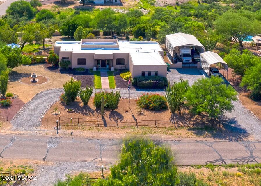 Lovely view home nestled on over an acre of property on a paved street in Vail. allows for horses and RVs on site. There is a 3 car garage and 2 carport slabs. One is 12 x 25' and one is 23 x 32' with 30 amp RV hookup. The property is only 15 minutes to major shopping and has Vail Water Company, many citrus trees, a 10 x 12 Tuff Storage Shed, & spa. Home boasts security windows & screens, ceiling fans, a full length back patio with access from master bedroom and living area. The current piano room could be formal dining room. Master bedroom has 2019 carpet, tub and shower, and a large closet. Both dishwasher and HVAC were replaced in 2019