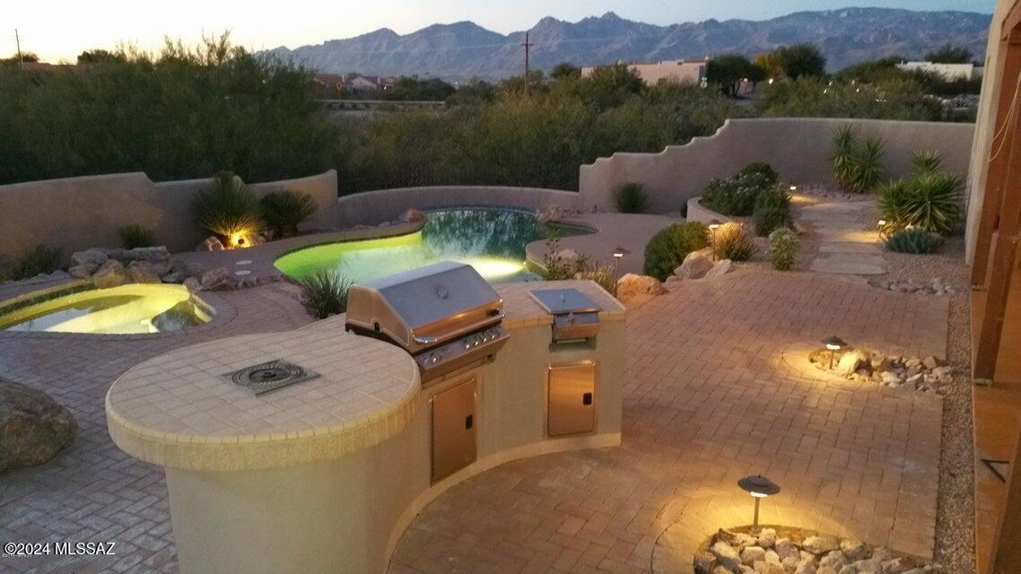 Lovely TJ Bednar Santa Fe style home with Viga beams. Inviting gourmet kitchen with granite counter, includes all appliances. Perfectly nestled on a private and secluded .60 of an acre (approx) in a quiet 12 home subdivision. Tastefully landscaped backyard with incredible views of the Catalina Mountains. Enjoy the pool & spa with a wonderful extended covered patio 20x40 with bbq & fireplace, perfect for the ultimate outdoor entertaining. Elegant primary bath with Travertine Tile. Irrigation system replaced in August.