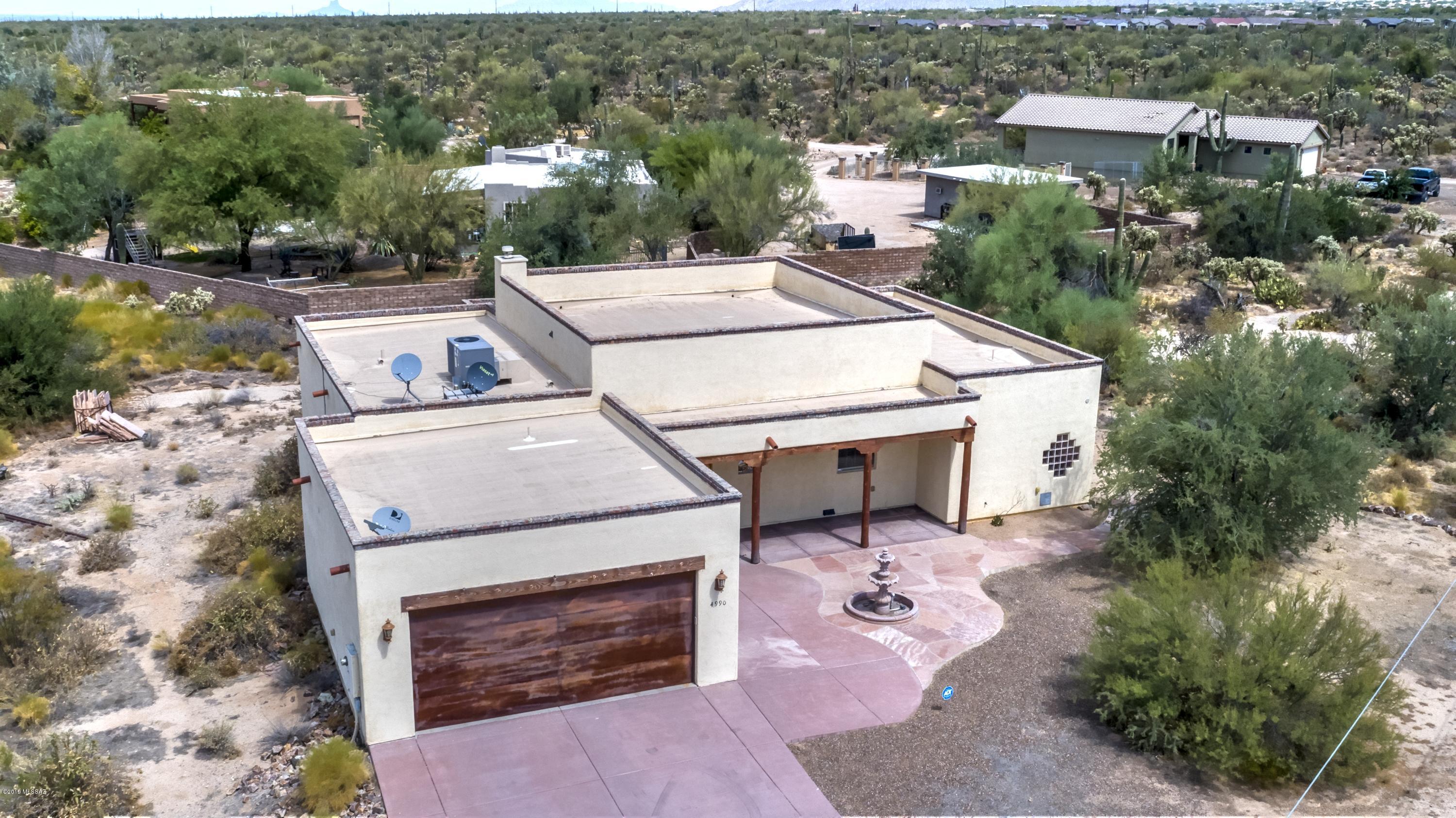 Private Santa Fe style custom home sitting on an acre lot filled with lush desert vegetation & 360 degree views.  This gorgeous NW home comes with an abundance of upgrades including an open split bedroom floor plan with high ceilings, luxurious kitchen with Dacor appliances, granite counters, cherry cabinets and island, travertine tile flooring, spacious master suite with walk-in closet, jetted tub, separate shower & granite counters, charming Cantera stone waterfall in foyer, custom faucets throughout, laundry room with washer / dryer, romantic gas fireplace, guest bedroom with loft above closet, covered patios, long driveway, oriented to capture the natural light and a popular Marana location conveniently located near shopping, restaurants, world class golf and hiking destinations.