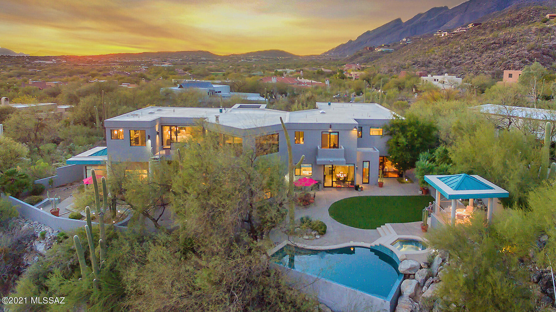 This stunning contemporary masterpiece w/ detached guest house is sited on 1.29-acres. Nestled against the Catalina Mountains, this is a true hidden gem that effortlessly showcases Tucson's beautiful city & mountain views. Enter home to an open floorplan w/ spacious living areas & contemporary design by John Campisano. This 6,566 sq. ft. estate has towering ceilings & walls of windows allowing plenty of natural light & divine mountain views. Entertain in kitchen w/ marble counter tops, upgraded appliances, & spacious walk-in pantry.  Luxury amenities abound w/ an intricate maple spiral staircase invites the upper level's 5 beds, all en-suite, where each room is paired w/ individual balconies & large closets. Seamless indoor-outdoor flow to backyard with resort-like spa/pool, BBQ, & Ramada.