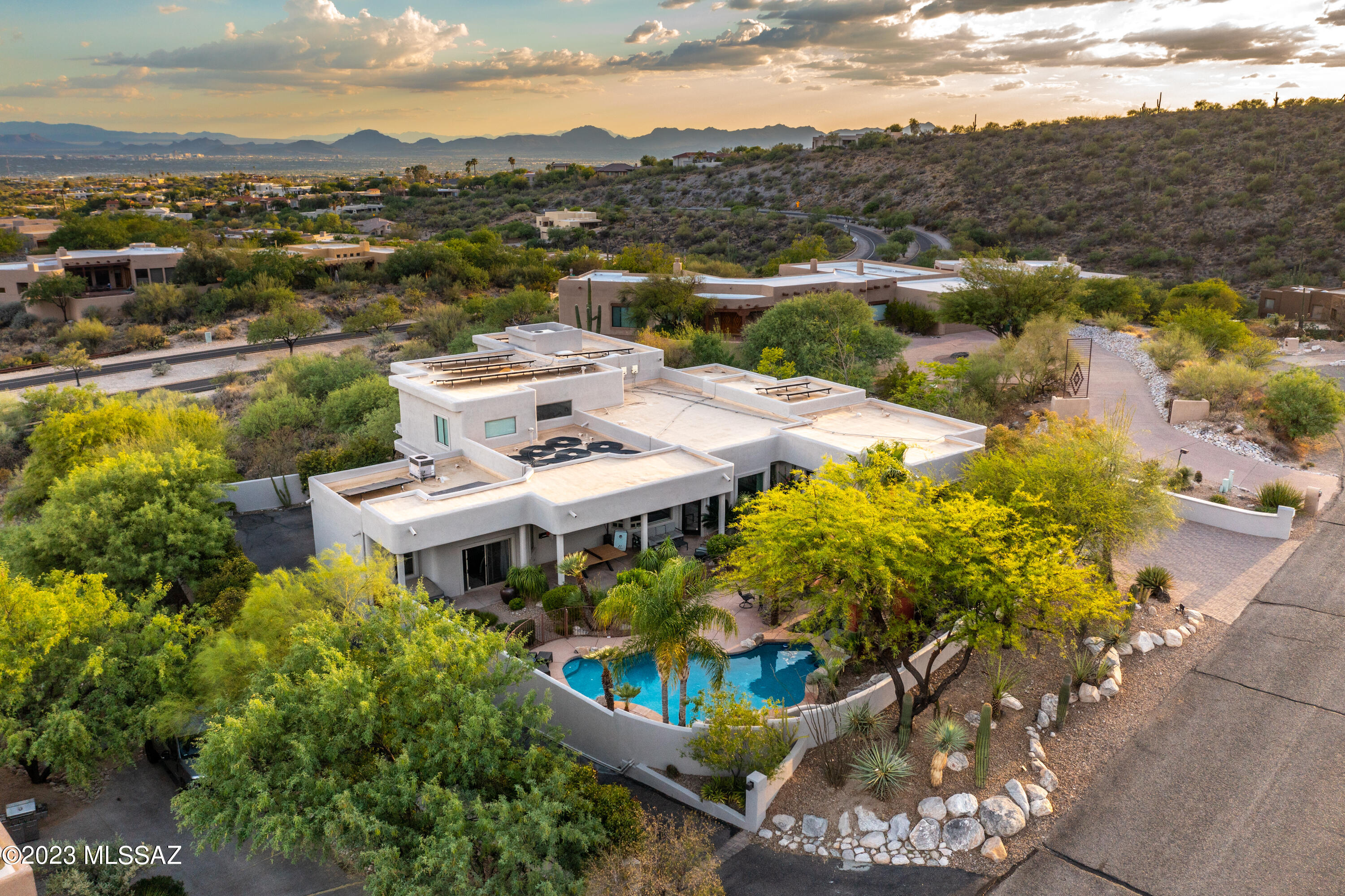 Welcome to this stunning home which has been thoughtfully transformed to provide an elegant modern living experience in the heart of the Catalina Foothills. Located in the prestigious Alta Vista neighborhood, this home will wow you at every turn! Custom designed by Baker and Hesseldenz, it has been meticulously enhanced and elevated to perfection by expertly combining contemporary aesthetics with livability and function. Features include a chef's dream kitchen with custom ebonized walnut cabinets, metal range hood, Subzero refrigerator, AGA Mercury range, sleek quartz countertops, plus a beautiful coffee bar and wet bar with wine fridge, and beverage and freezer drawers. The modern concrete floors seamlessly connect the casual dining area with soaring ceilings and expansive windows to... bring the beauty of the Sonoran Desert inside. A large formal dining area with a gorgeous chandelier and lovely ceiling features completes the open living space. The primary suite, located on the main floor, is a true retreat, with a custom designed stone gas fireplace and large windows with top-down/bottom-up shades for light and privacy. The impressive en-suite bathroom features dual vanities, a soaking tub, a spacious separate shower, and a walk-in closet with a top-of-the-line Avera organization system. Two additional upstairs bedrooms each feature ensuite bathrooms and a shared living area with incredible views. The main floor also features an office space and fabulous living/music room, with beautiful lighting features, custom-built shelves for vinyl display and storage, and mesquite hardwood floors. Full bathroom next to office leaves open option for a 5th bedroom. The home also provides a fully remodeled and self-sufficient guest quarters, which includes a full kitchen, washer/dryer, and full bath, accessible though the kitchen (for use as 2nd prep space while entertaining) or locked from main house with separate outdoor entry. Wonderful "rec room" with a custom climbing wall provides a great place to enjoy activities indoors when the temperatures rise, however, given its separate AC, private yard, and great light, the space could be transformed to many other uses if desired.  The resort-style outdoor living space offers an expansive covered patio with hot tub, turf grass area, sparkling pool with a swim up bar and waterfall, plus a full gazebo, covered outdoor kitchen and seating area. This oasis-like setting is perfect for entertaining or simply enjoying quiet moments.  Owned solar panels provide for lower electrical utilities and the solar coil heating system adds months to Tucson's wonderful pool season.  Just minutes from Ventana Country Club, hiking trails, shopping, and dining. With its impeccable design, luxurious updates, and prime location, this home is the ultimate place to live your best life in Tucson.
