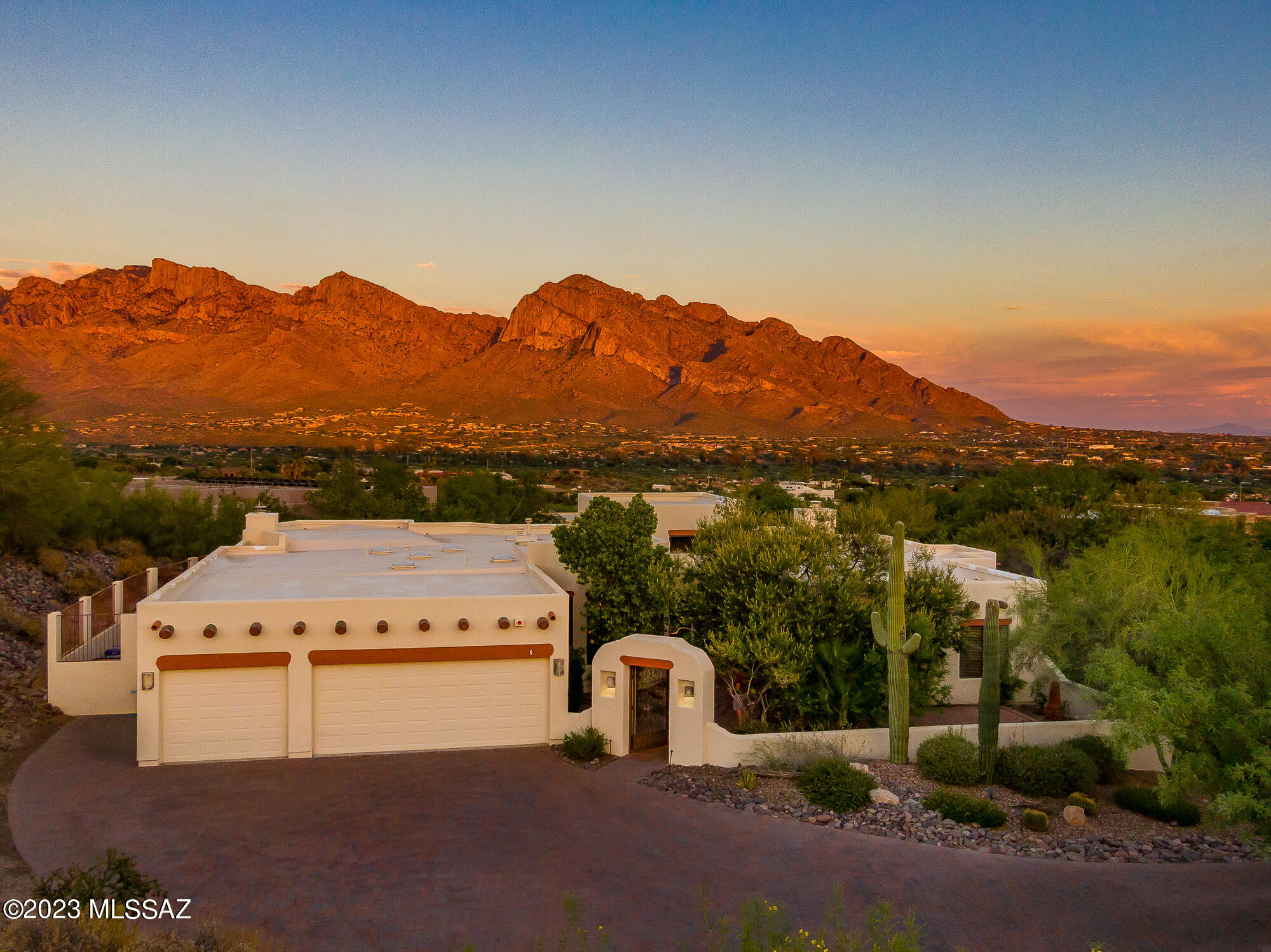 Gorgeous ridgetop custom home in prestigious gated Canada Hills Estates with terrific views of Pusch Ridge and the Santa Catalina Mountains. Spacious 4 bedroom, 3 bath Santa Fe style home with separate living room, family room, and formal dining room, plus high ceilings, tiled floors and 2 fireplaces. Large rear yard has lots of room for entertaining, great views, professional landscaping, multiple patios, a negative edge pool, and a large spa. Recently professionally updated with fresh interior and exterior paint, all new stainless steel appliances, new granite counters, refinished cabinets, new sinks, & a large new tub. Custom built by Michael Almli with high ceilings, dramatic entry, oversized 3 car garage, and great window spaces to take advantage of the view. Private front courtyard. Numerous mature fruit trees in back. Long driveway and large parking area with custom block pavers. Excellent schools, shopping, and parks nearby. Situated on a high lot at the end of a cul-de-sac. Single story home, but with 2 steps down to the bedrooms on the south end of the house. Roof just refurbished and recoated and under warranty. Several large picture windows just replaced. Two HVAC units, two water heaters, and a central vacuum system.