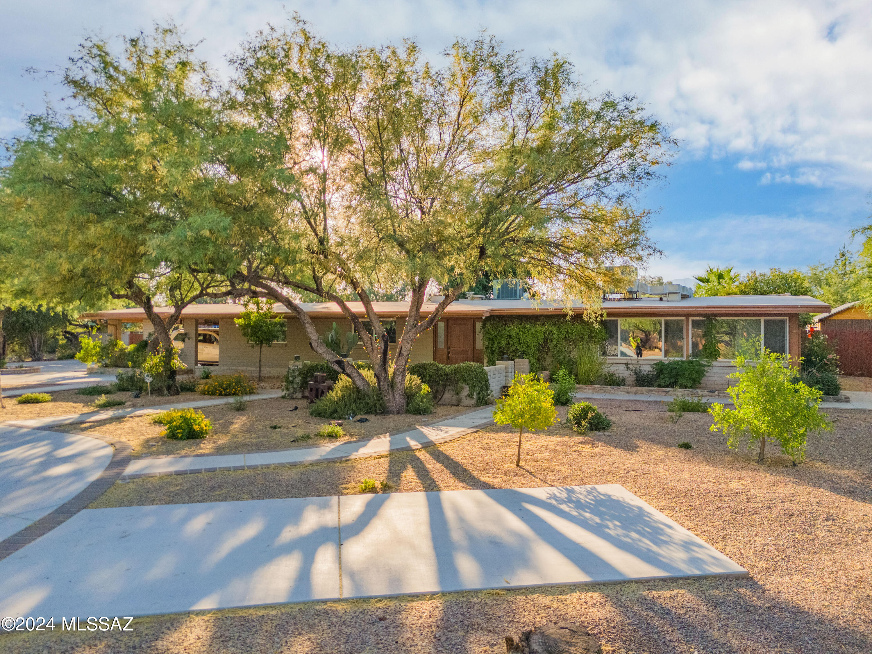 Come take a look at this gem located in the desired Bell Air Ranch Estates. In the heart of the Tanque Verde valley this property has so much to offer including a full guest house, basketball court, pool, and so much more. As you pull up to the home you will see all the beautiful concrete driveway work providing tons of parking and space. The 1 acre property has mature landscaping in the front and back including many fruit trees. The main home features 4 bedrooms and 3 full baths. Home has many updates including all the bathrooms and the stunning kitchen. The guest house was designed with comfort and style in mind. Featuring 1 bedroom and 1 bath and open concept kitchen and living room. The whole guest is ADA friendly with a ramp leading to the home, wide doors, and wide shower access. Come see this outside oasis with large covered patio with grill set up, in ground trampoline, basketball court, playground, large shed, and space for so much more.