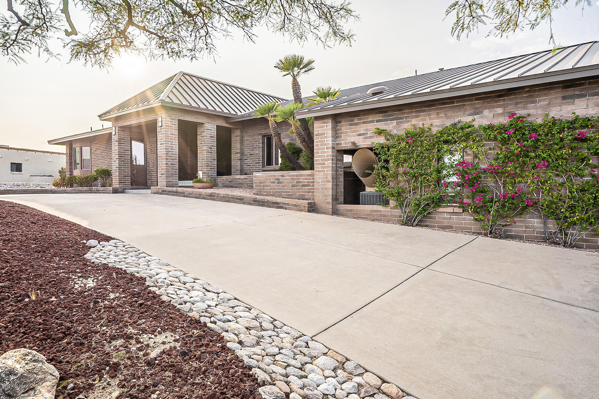 Perched on a Ridge top with endless majestic  Catalina Mountains and City views!  Enter to a grand foyer with vaulted ceilings & wood beams throughout the home.  Plenty of natural light, open floor plan, remodeled kitchen with a huge granite island , Alder wood cabinets  & Thermador SS appliances.  Newer metal roof with lifetime warranty,  Library with built in shelves, electric window shutters throughout.  Come home and entertain your family & friends in a 20 ft game room,  dance studio/ exercise room,  very large pool with outdoor 3/4 bath,  built-in BBQ.  Enjoy beautiful sunset views from your back patio or grass /play area. Huge 1,614 Sq/Ft 5 car garage with plenty of storage.  5 Minutes to Whole Foods  & Rillito River Loop to walk, hike and bike.