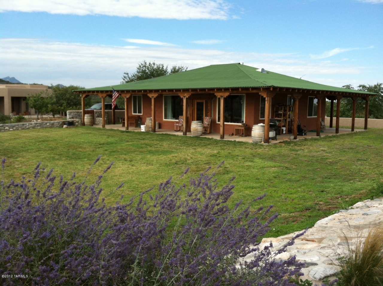Reminiscent of days gone by this charming home with wrap around porches welcomes all to pull up a rocking chair and watch sunrises, sunsets, summer rains, and wildlife come and go. Built from reclaimed lumber, rastra block and ondura corrugated fiberglass asphalt roofing this home is energy efficient and green. Situated on 2 acres with 360 degree views, this property has over 130 grape vines on irrigation and is perfect for anyone dreaming of a hobby vineyard. Bright and cheery with 10' to 14' ceilings and large Low E rated windows. Block wall, oak trees, privacy. This little home has a lot including a small price!