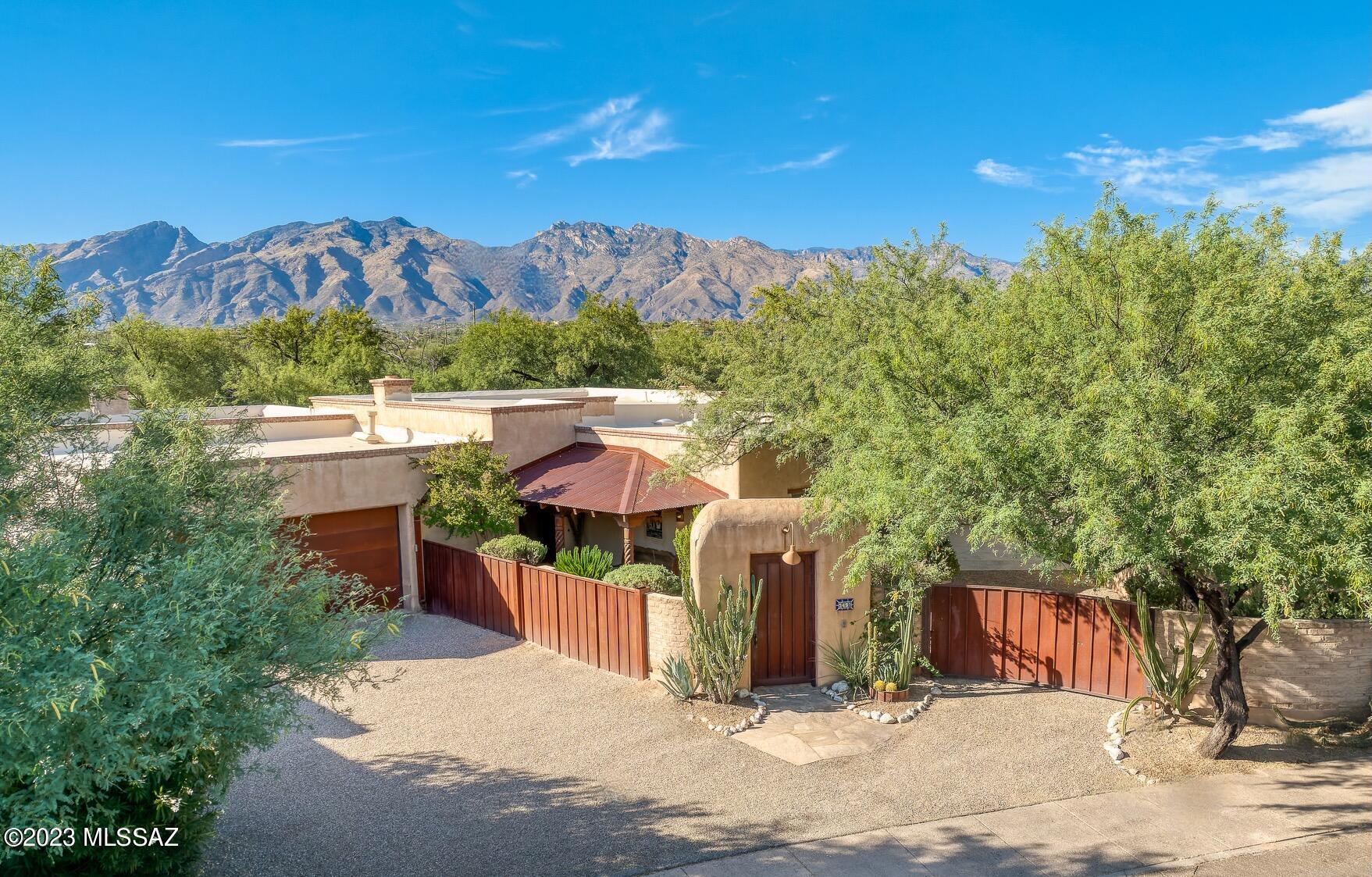 An authentic Mud Adobe located in the highly sought after Adobes Del Bosque community within the historic Ft. Lowell District, meticulously hand-built, using craftsman techniques and materials, with all the modern conveniences of today. Enter through the private courtyard into a high design interior space that complements and reflects this regional vernacular, utilizing a delicate balance of tones, textures, and finishes, providing the ideal backdrop for the individual design sensibility. Constructed of stabilized Mud Adobe, this mass wall system offers substance, as well as thermal properties, perfectly suited for our desert climate. 2,604 square feet (2,136 Main + 468 Casita) of interior living space, consisting of 4 Bedrooms and 3 Bathrooms, with an attached 2 car garage and 4 car covered carport, accessed through its own private motorized gate. 

Upon entry one is greeted with archetypal wood beamed ceilings, specific to the vernacular, and stretching the length of the great room, with proportions that provide volume of scale and space, while also retaining a welcoming sense of intimacy. Sited on an ideal North/South axis and beyond the home's traditional Territorial reveal, one is greeted with authentic, hand trawled integral colored plaster textures, complimenting the exquisite attention to detail, providing both a visual and tactile experience. Exposed concrete floors, juxtaposed against plastered and exposed Mud Adobe walls, enhances the visceral feel of the natural materials from which this home was constructed. 

The kitchen's disciplined design features are set off by the Viking stainless steel professional series appliances, with custom alder wood cabinetry, wrapped in concrete countertops and set against traditional Talavera tile backsplash, overlooking the great room living spaces. A sumptuous owner's suite is privately sequestered on the West wing of the residence and is ideal for those in search of a split bedroom floor plan. A series of exterior doors and windows open onto the grounds, filling the room with soft, natural light, providing a reintroduction to the home's effortless blend of laissez-faire. 

Maximizing the dramatic relationship between interior and exterior spaces is achieved through careful design and placement of the structure with connectivity to the surrounding desert landscape. Layers of covered patios are perfectly suited to enjoy year round, with views stretching out over the thoughtfully curated yardscape, creating the perfect framework for the sun drenched pool and elevated spa, acting as the centerpiece of this classic courtyard vernacular home.