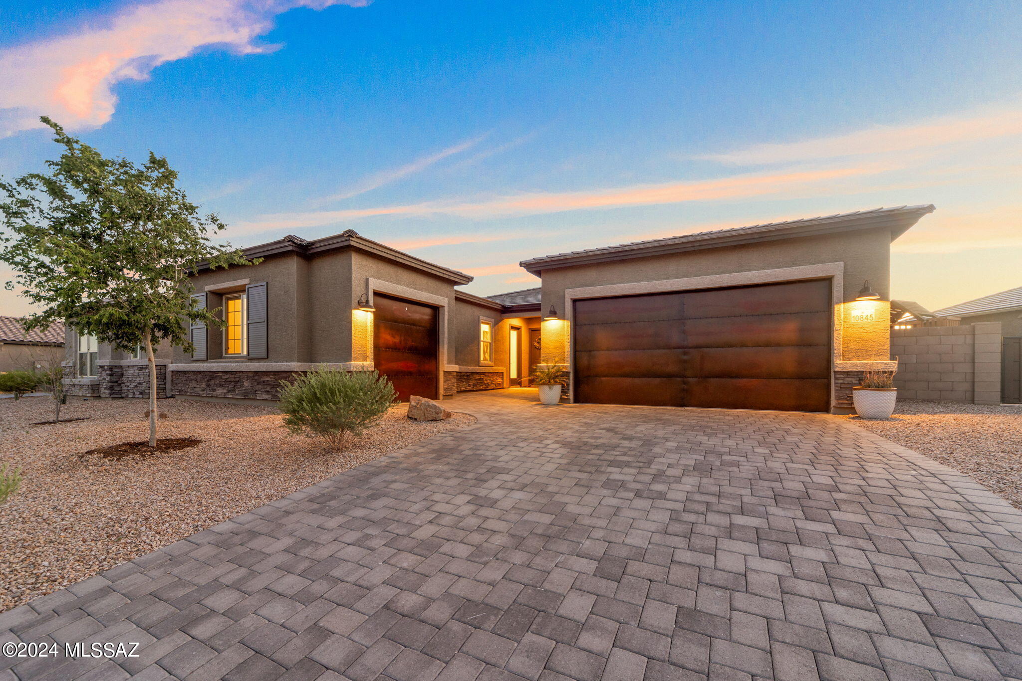The perfect alternative to new construction inside the gated community, The Estates at Capella. Completed in 2023, this property has been further upgraded by the owners for a true turn-key experience that marries form and function. Situated on a large quarter-acre lot with gorgeous desert landscape behind, a true sense of privacy is experienced within this neighborhood setting. Inside the home, a warm neutral palate creates a calming atmosphere, enhanced by the views of saguaros and green. Spanning 2,630 sq ft, the efficient layout offers a variety of options for residents. The split floor plan includes 3 bedrooms, 3 full bathrooms, an office, and a spacious bonus room or guest space with its own exterior entrance and wet bar. Elegant elements are found throughout: a stone clad gas fireplace, modern ceiling fans, knurled cabinet hardware, vertical backsplash, fresh lighting, and custom woodwork. Blinds in several spaces are remote control operated.

The bonus room works well as the owners use it today (game room), however, dedicated guest quarters could be set up in that space to include: bedroom, bathroom, living room, laundry hookup, and dedicated ingress/egress.

The separate 3rd bay garage can be accessed from the interior or exterior, adding the option for a gym, workshop, art studio, playroom, or storage.

The outdoor areas have been fully finished and are ready to enjoy. A blend of hardscape and stone is pleasing to the eye, while providing areas for both seating and plantings. The perfectly positioned hot tub creates a natural sightline to the desert and amazing sunsets. Separately gated (and offering a double exterior gate), the expansive side yard is outfitted with artificial turf and raised beds, ideal for play, pets, and gardening. The property is still under many of the builder & manufacturer warranties.

Lifestyle elements and amenities from this location are plentiful. Both Ironwood Ridge High School and Casas Christian School are walkable, while Wilson K-8 is 1.5 miles. Access to a paved multi-use path that connects to "The Loop" is just outside the gate for walking, running, or cycling. Within 2 miles, you will find the Oro Valley library, Naranja Park, and plazas with grocery, dining, pharmacies, and other services. This location boasts all the benefits of living in Oro Valley, while sitting a bit further south, making commuting or traveling Downtown quicker.