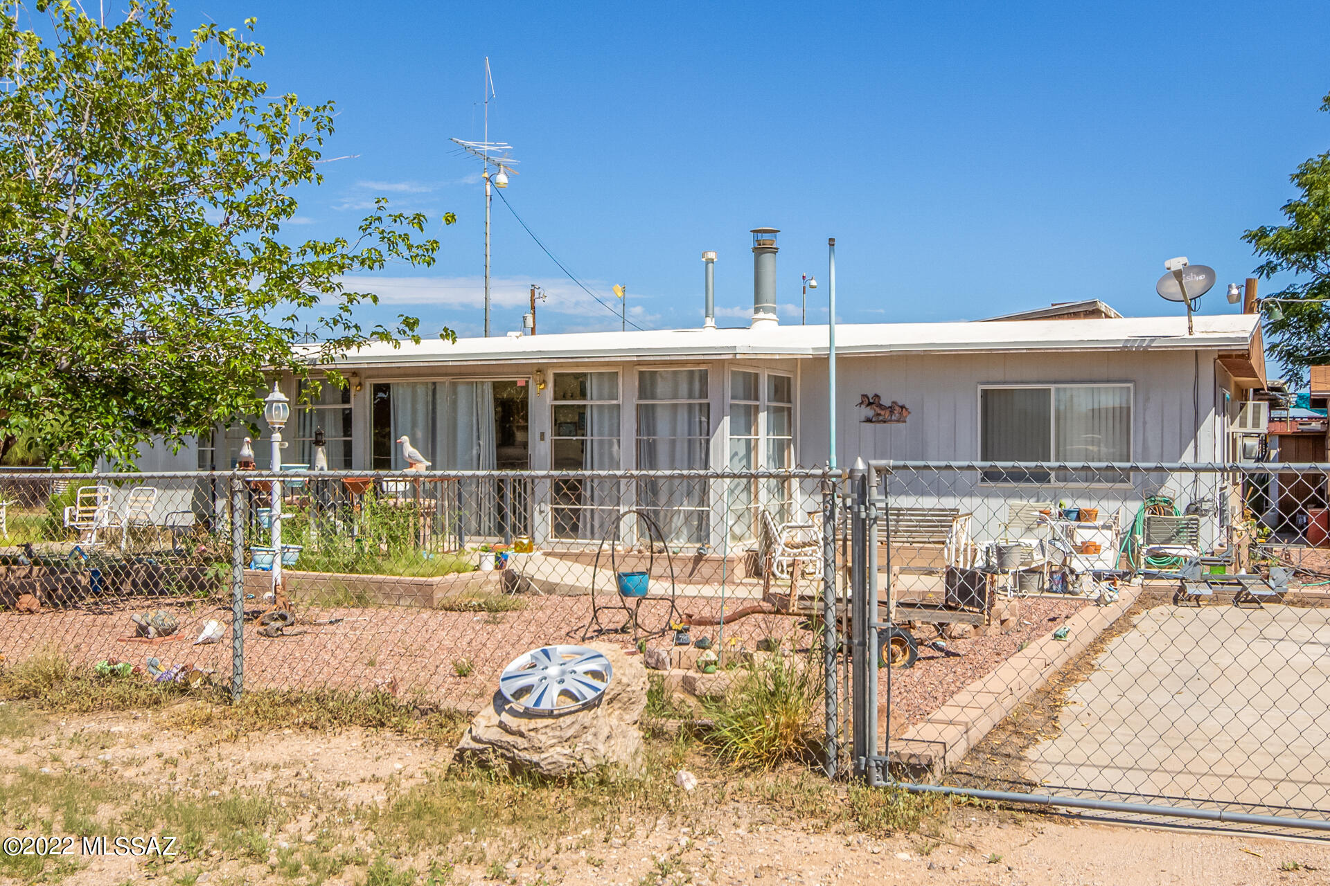 Welcome home to this wonderful home on a corner lot. Newer roof and plumbing! Covered parking w/ electricity ran, high enough for RV parking & comfortable AZ room at the entrance. Come inside to discover the spacious living room, wood walls & soft carpet. The eat-in kitchen features built-in appliances & wood look flooring. The primary bedroom boasts ample space & private bathroom w/a walk-in closet. 2 additional rooms, big enough for easy bedroom conversion. The sizable backyard enjoys a relaxing covered patio & a separate building with a mini split for the washer and dryer! *Estate sale will be finalized mid October. All personal items will be removed prior to COE*. New roof and plumbing!