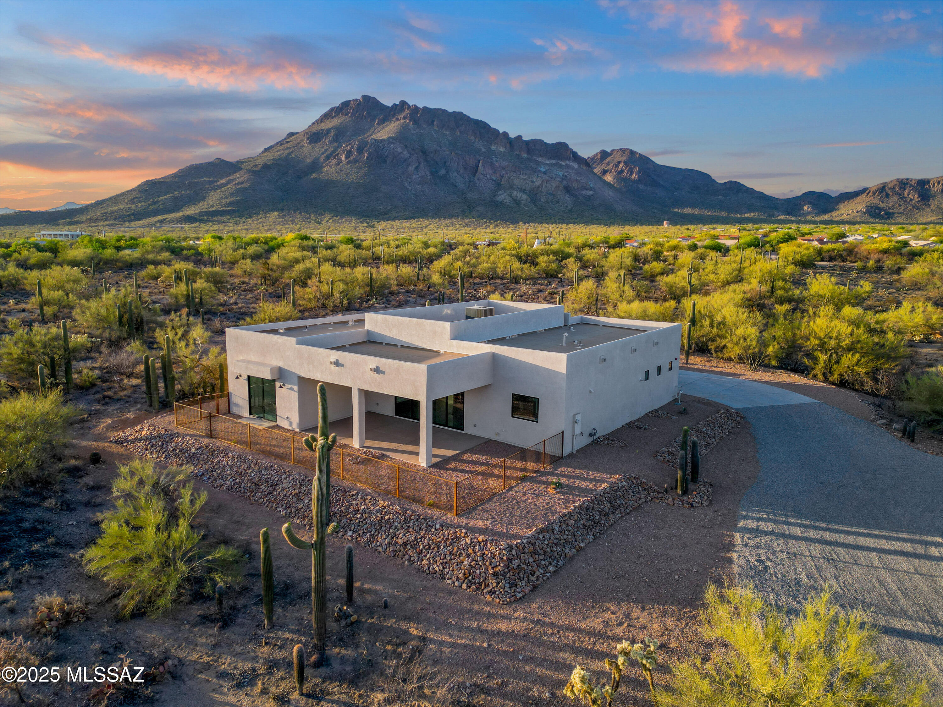 Nestled in a highly desirable neighborhood just beneath the Tucson Mountains, this stunning new build sits on an expansive 3.3-acre lot with no HOA offering both privacy and freedom. The extended driveway and professionally landscaped exterior create a striking first impression. Inside, the open concept floor plan is filled with natural light, showcasing elegant flooring, a soft neutral palette, and an inset fireplace that adds warmth and charm.

The gourmet kitchen is a chef's dream, featuring a double oven and modern finishes perfect for hosting or everyday living. The luxurious owner's suite includes double vanity sinks, a walk-in shower, and a spacious walk-in closet. Additional closets throughout the home provide abundant storage and organization. Builder thoughtfully added roof infrastructure to support future solar panels, allowing for a seamless and discreet installation that won't impact the home's beautiful design.

Step outside and enjoy the serenity of Arizona's breathtaking sunsets and sunrises. With plenty of space to relax or entertain, the backyard becomes your private oasis. Best of all, this peaceful retreat is only minutes from major shopping centers, I-10 access, and more.