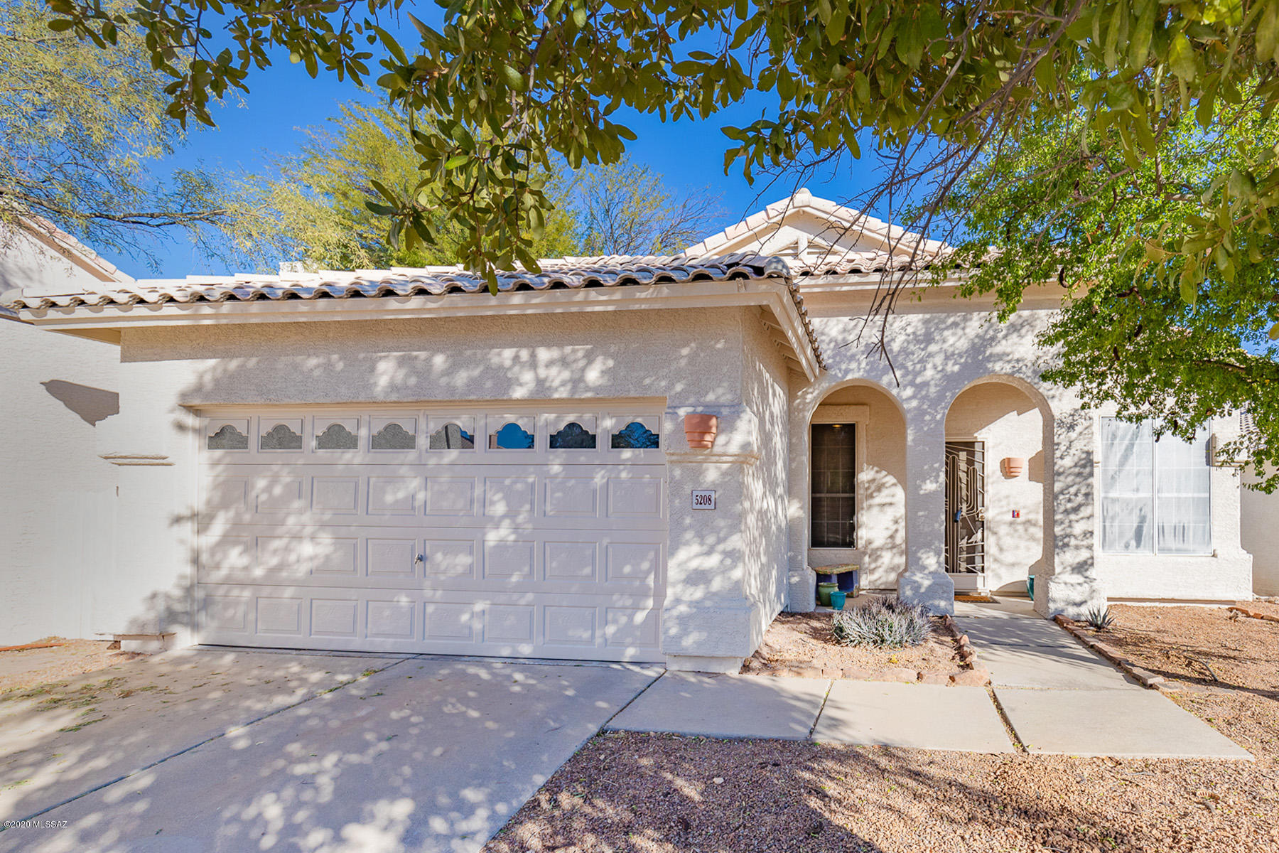 Privately sited against a heavily vegetated arroyo, this wonderful home boasts practical tile flooring throughout.  Dramatic vaulted ceilings, oversized arched entries and an abundance of windows and glass doors keep spaces open and light and bring mountain views in.  The kitchen features stainless appliances w/gas cooking.  The spacious master suite boasts a walk in closet, dual sinks, vanity area, garden tub and separate shower.  A custom tiled fireplace is the focal point of the family room along with the mountain views.  The rear yard offers an extended covered patio off a no care grass yard with the lush arroyo backdrop providing privacy.  Close to Sabino Canyon shopping and schools.  Freshly painted and ready to move in.