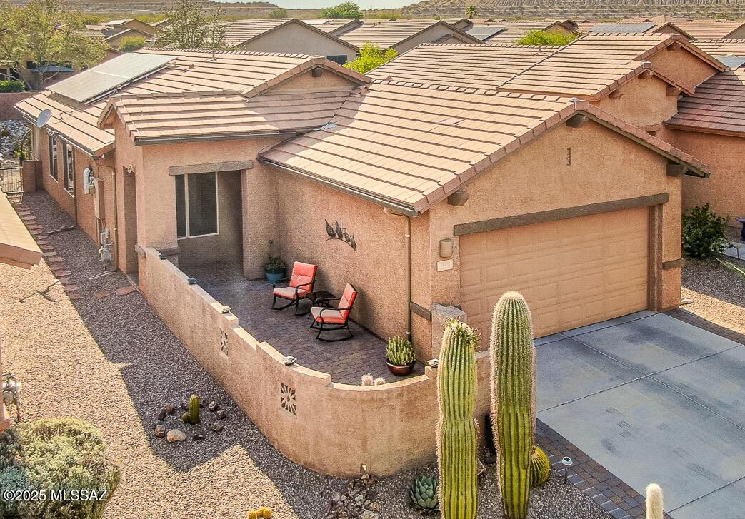 Absolutely beautiful & impeccably maintained home in desirable Las Campanas!  Enter through the peaceful front courtyard & take in the views of the Santa Ritas. Inside, the kitchen wows w/ granite countertops, pull-out drawers, pantry, & dining area. It also includes a new disposal & is plumbed for a gas stove if desired. The kitchen opens to a spacious  & welcoming living room, ideal for both everyday living & entertaining. You'll find rich offset tile flooring throughout the main areas, w/carpeting in the bedrooms for added comfort. The split-bedroom floor plan offers privacy for you & your guests. The primary suite provides a true retreat, complete w/ bonus space for a home office, reading nook, or TV area. Solar efficiency to save on your electric bills.  Step out back to the serene screened-in porch and enjoy the peaceful, oasis-like backyard, your own haven where you can truly relax. The 2 car garage features an extra workshop area for any of your hobbies. Newer water softener too. This gorgeous home is move-in ready and waiting for you. Don't miss this gem!