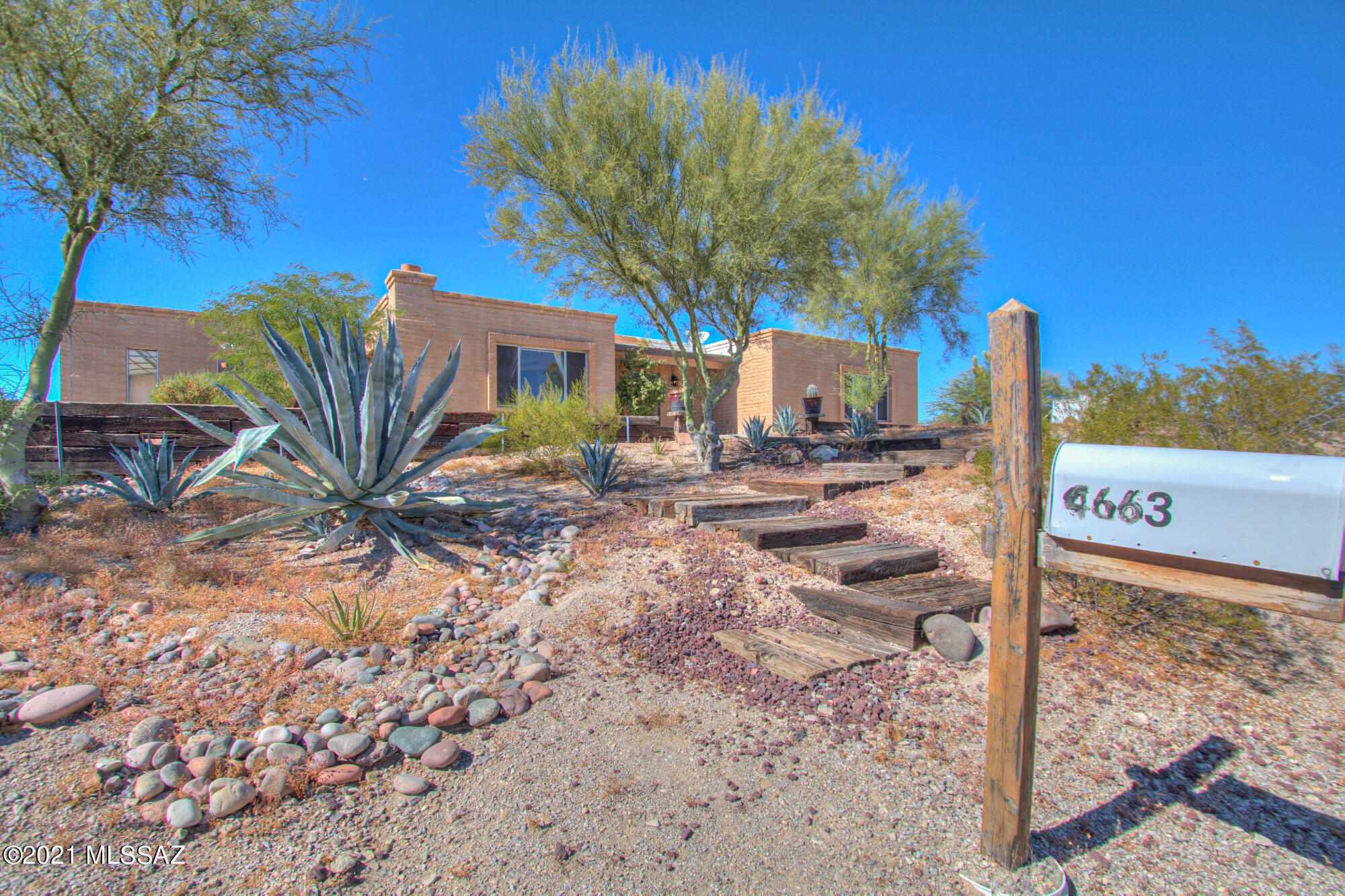 Enjoy this 3 bedroom territorial/ranch style home on a elevated view lot.  Slump Block construction, island kitchen with dining area, separate living/family rooms, wood burning brick fireplace, 2 car garage with attached workshop/hobby room that could possibly be converted to guest quarters.  Terraced rear yard with block wall area includes an extended patio and room for a hot tub or spa.  Corner Lot