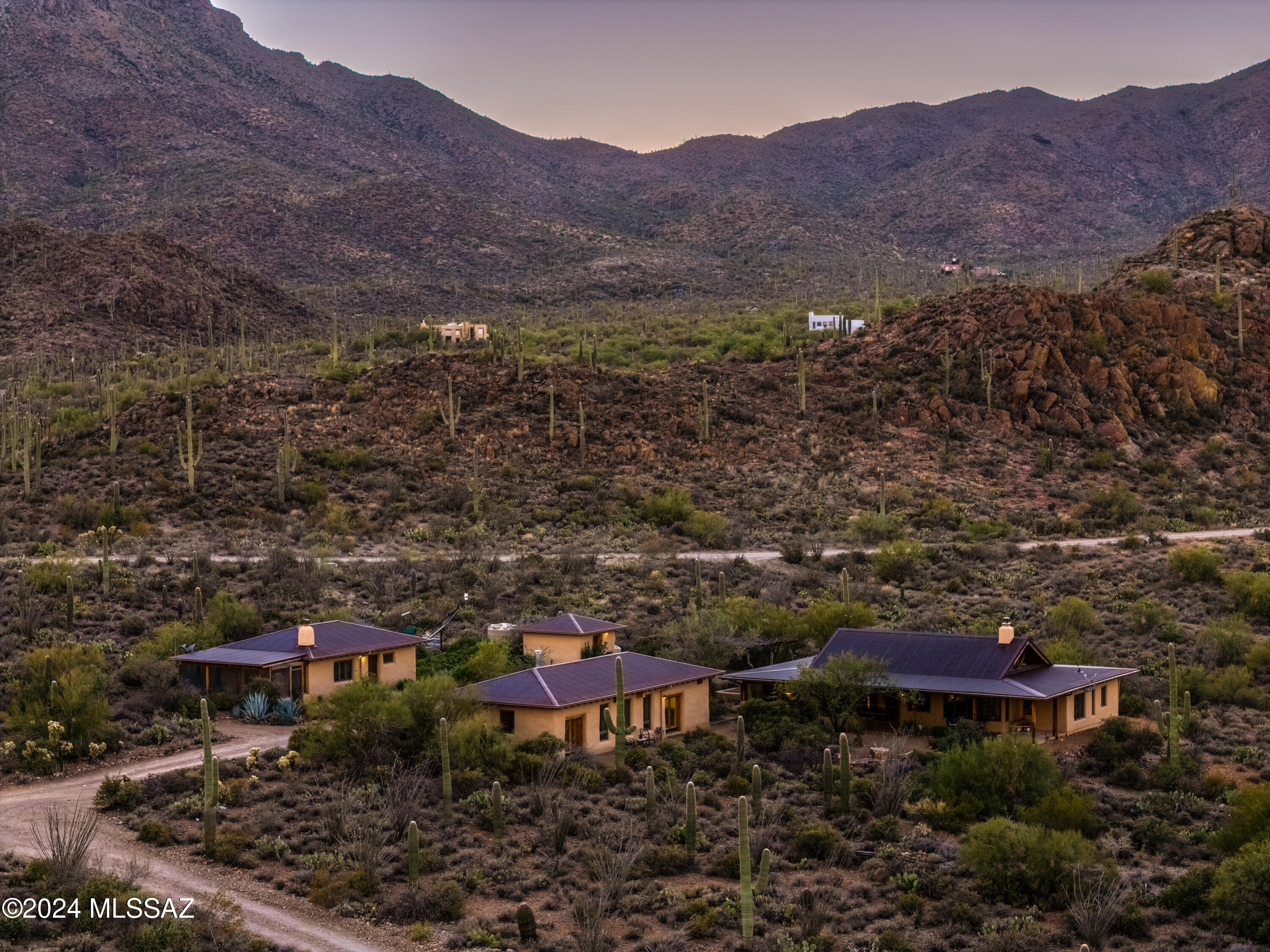 Nestled in the heart of the Sonoran Desert on 3.56 acres, this unique one-of-a-kind custom straw bale post and beam home with wood pin construction offers a harmonious blend of sustainable design, breathtaking natural beauty & panoramic city views from every angle. In 1998, builder John Woodin, architect Paul Weiner, and plaster expert Jill Lorenzini brought Lou Rudolf's vision to life, the home embodies the pioneering spirit of eco-friendly living. The property features 3 separate buildings, including the main home 1874 sqft, a charming guest house 640 sqft & a versatile studio/workshop1100 sq ft.  The studio is fully heated & cooled 554 sqft, with potential to add a kitchen & bath, making it an ideal space for a home office, art studio, or future living quarters With thoughtful design & unparalleled flexibility, this property is perfect for those seeking space & inspiration.
Every window offers breathtaking views of the vibrant cityscape by day and glittering lights by night, while the serene Sweetwater Preserve provides a natural sanctuary just steps from your door. Living here feels like residing in your own national park, where sunrises and sunsets paint the desert canyon with vivid colors.
Lovingly restored in 2021, this property has been brought back to its original grandeur while preserving its charm and character. Modern updates blend seamlessly with its unique design, creating a home that is both inviting and functional. The surrounding 3.56 acres provide ample room for privacy, recreation, and the ultimate connection to nature.
This property is more than a home it's a lifestyle. Enjoy morning walks through the Sweetwater Preserve, the kindness of a welcoming community, and the self-sufficiency that comes with life in the desert mountains. If you've ever dreamed of living where the desert meets the sky, with city views as your daily backdrop, this is your chance to own a truly special piece of Tucson's history.