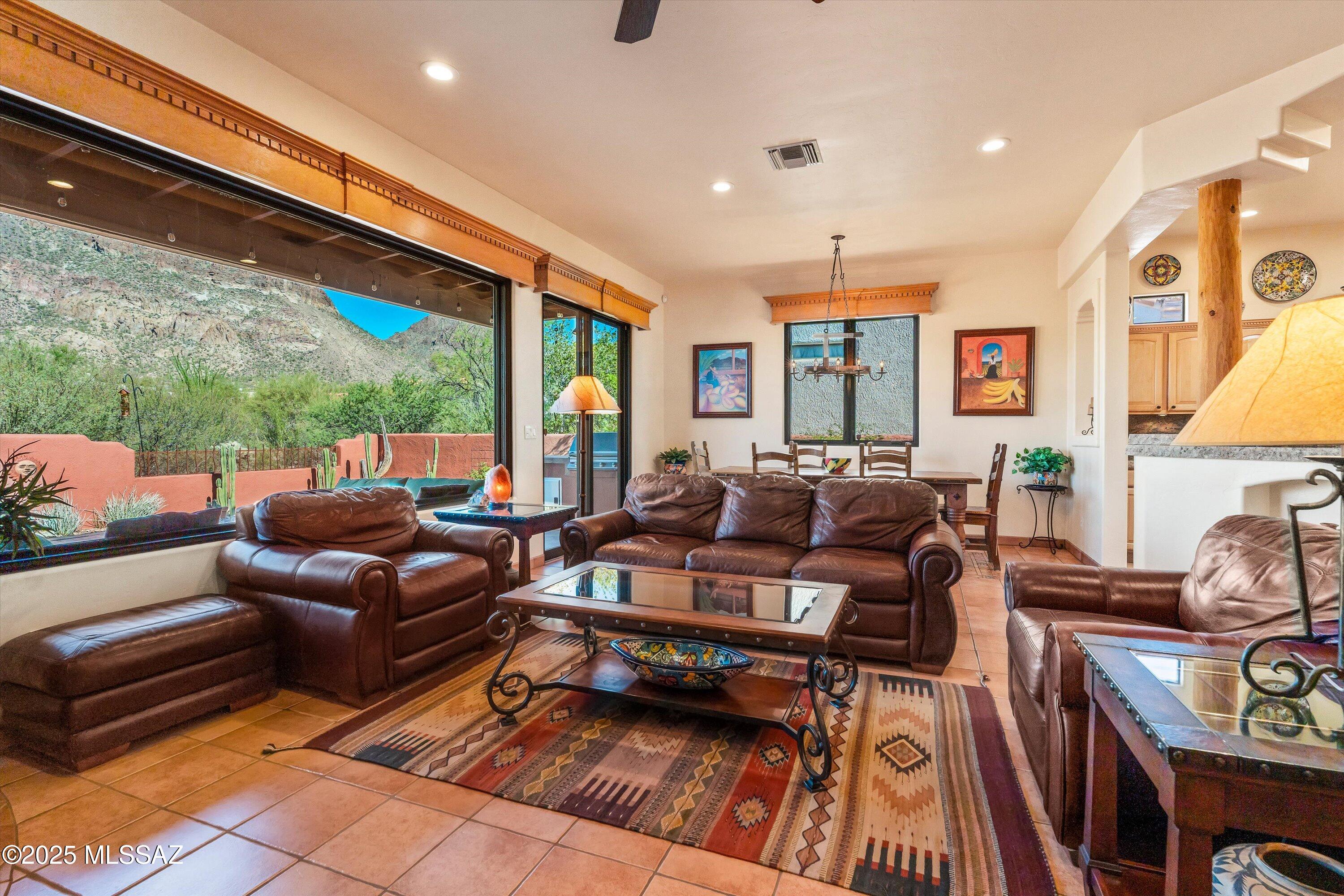 OWNED SOLAR! This beautifully maintained semi-custom home captures the essence of desert living with thoughtful upgrades, modern comfort, and incredible views of Golden Gate Mountain. Recently refreshed with a freshly painted exterior, new skylights throughout, and front and backyard irrigation completely re-done, this home shines inside and out. Even the back wall has been modified to fully showcase the breathtaking scenery.
Located in the sought-after Tucson Estates 2 community, this open-concept 2-bedroom, 2-bath plus den residence offers refined living with custom wood doors, ceramic tile flooring throughout, and chiseled-edge granite in the kitchen, bathrooms, and laundry. Enjoy the efficiency and beauty of Pella Low E windows and a top-of-the-line Fleetwood patio slider, along with a whole-house water filtration system and more.
The chef's kitchen flows seamlessly into the great room, where a cozy fireplace and a stunning 10-foot picture window create the perfect setting for gatherings with family and friends. Step outside to the north-facing patio and enjoy year-round comfort under four Bromic electric heaters or gather around a future firepit using the pre-installed gas connection.
Wake up each morning to unobstructed mountain views from the primary bedroom - ideal for enjoying a quiet coffee or smoothie while soaking in the beauty of the desert landscape. The en suite bath offers a true retreat with a double vanity, generous walk-in shower, and custom mirror framed by natural light.
A true desert gem, this vibrant community offers resort-style amenities including a pool, spa, clubhouse, tennis and pickleball courts, volleyball, bocce ball, and direct access to miles of hiking trails within Tucson Mountain Park.