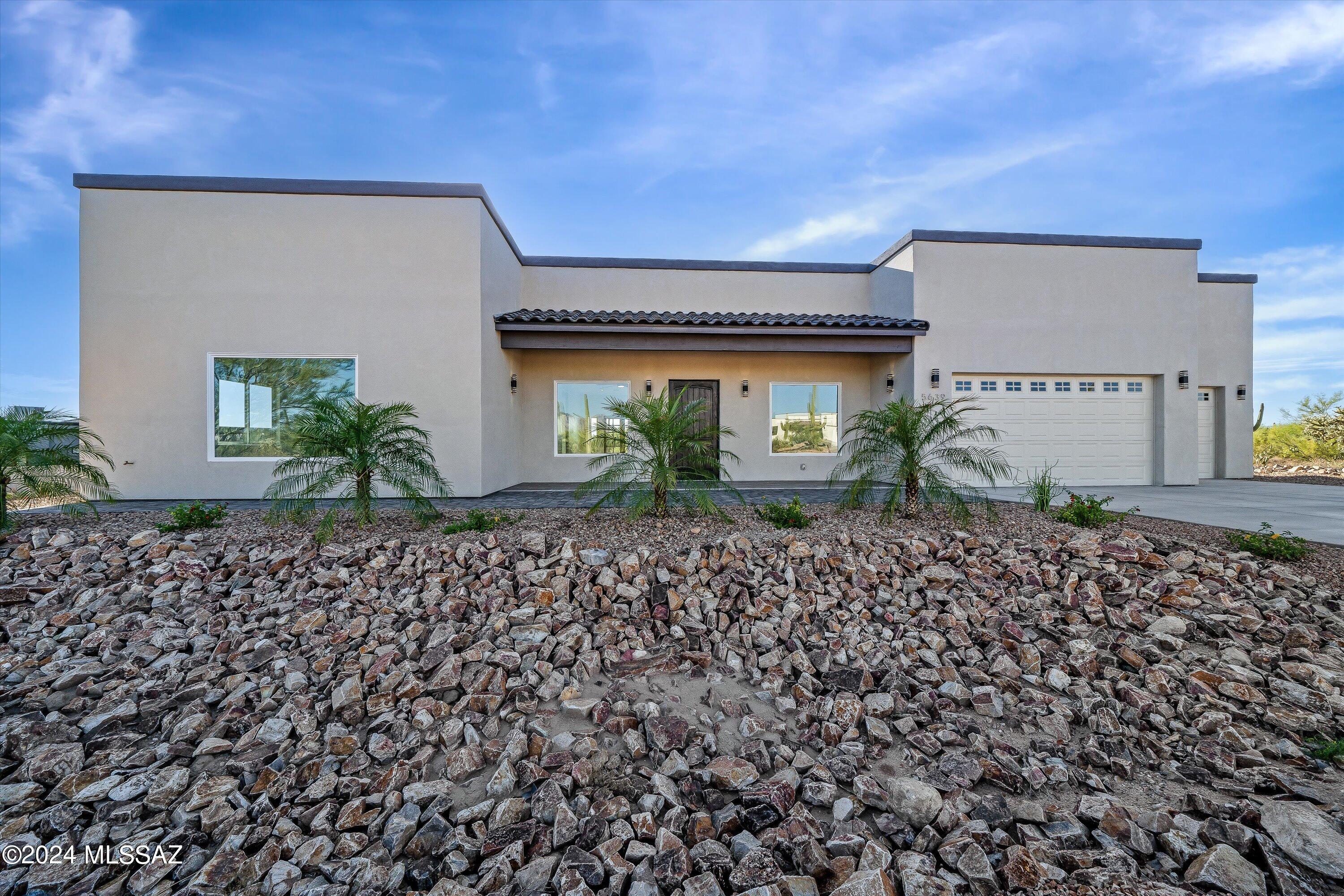This home is a gorgeous sanctuary among the beauty of the Tucson desert. With high ceilings and open area to create the dream home you have been waiting for. The home has beautiful tile flooring and stone countertops throughout. Split spacious 4 bedroom floor plan with 3 bathrooms equipped with Bluetooth in the mirrors that illuminate stunning lighting with a background of an exquisite blue accent light. The bedrooms have immense walk in closets with built in shelving units. The laundry room is a large spacious room within itself. Heading into the 3 car garage, you will find an enormous amount of storage along with an outlet to charge your electric car. Backyard is equipped with built in BBQ, refrigerator, sink, and ceiling fans for your enjoyment overlooking the natural desert beauty!