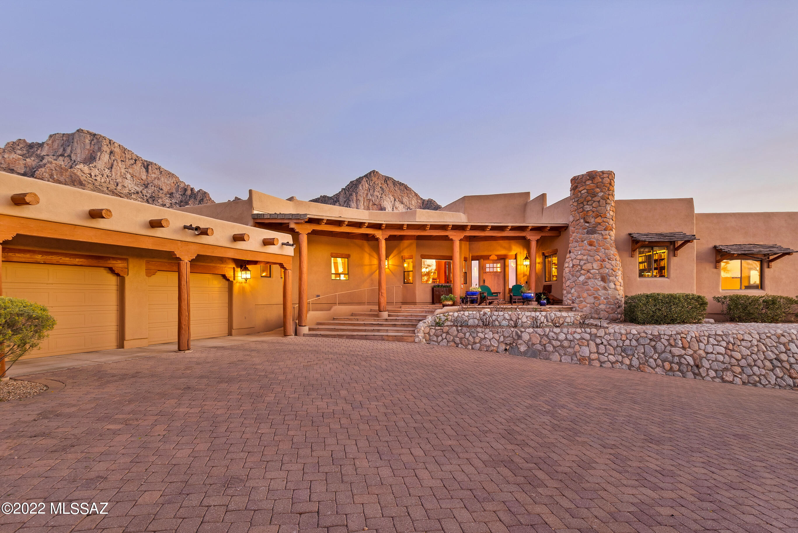 Immerse yourself into the true surroundings of the Old Pueblo with this stunning Santa Fe Style estate.  Located in the guard gated La Reserve Community at the base of the Catalina Mountains and Pusch Ridge, this home will not disappoint.  It backs to protected National Forestry land so you have truly unobstructed, jaw dropping city and/or mountain views from every corner.  Offering 4,251 s/f of living space this home's floor plan moves nicely and has a warmth throughout with its charm and character, beautiful beams and desert backdrop.  From the moment you step into the large foyer, you are captured by the most amazing views offered in Oro Valley. The family room off the kitchen provides plenty of space for furniture placement, beehive fireplace and step down breakfast nook.  Separate... living area can be used for additional tv room, game room, library, you name it. The large kitchen provides high end appliances, walk in pantry, island with gas cooktop, warming drawer, desk area and plenty of cabinet and counter space.  Just off the kitchen is a breezeway with backyard access and a dumbwaiter to the lower garage spaces.  This home features a split bedroom plan with the 4th bedroom currently used as a den with the second of three beehive fireplaces located here.  The other two generous size guest bedrooms have a Jack and Jill bath in between them.  The owner's suite is truly a retreat with more beams, the third beehive fireplace, separate sitting area, wrap around closet, walk in shower, jacuzzi tub and two access doors to the back and side yards.  The outdoor spaces will certainly not disappoint!  On the north end you have the Catalina Mountains as the backdrop for the pool & spa, multiple sitting areas, BBQ, and pool bath complete with shower.  On the south end you have a park like setting with wonderful desert landscaping and a sitting area to enjoy those Arizona sunsets and Oro Valley city views.  There are 3 garage bays.  The smaller 3rd bay is separate from the main 2 and is heated and cooled and features a half bath.  Be sure to watch the showcase video! Don't miss out on the peace and serenity this home offers.