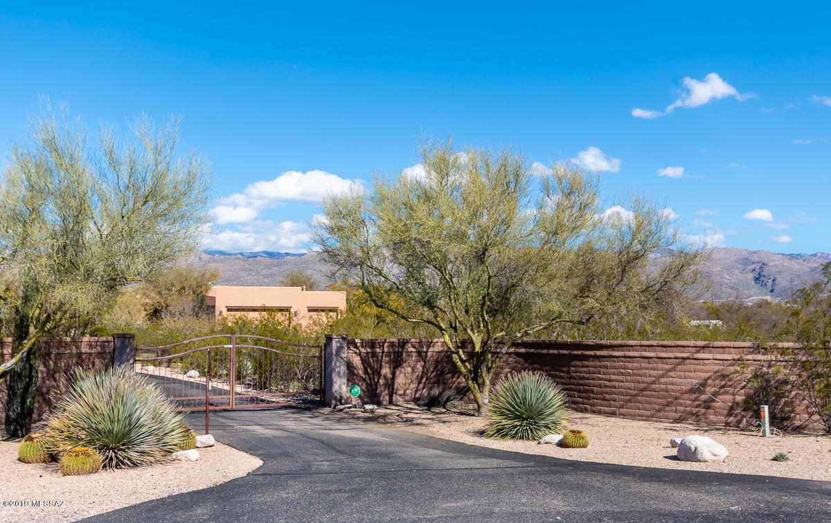 Exquisite gem located in the heart of the Tanque Verde Valley. This private & serene 3.3 acre property has it's own gate for added security & beautiful curb appeal. You will experience a warm & cozy feeling in this bright & spacious home w/ all of the right custom designer touches. Enjoy a split bedroom floor plan w/ 4 bedrooms & 4 bathrooms in the main home & 1 bedroom/1 bath guest house. Soft & neutral concrete floors through out home & master w/ wood floors in the bedrooms. Popular great room style home w/ custom stack stone gas fireplace & 8 FT doors through out. North facing backyard patio overlooking pebbletec pool/spa/waterfall, professional landscaping,  & unobstructed Catalina Mountain views. Room for all toys w/ expansive flat usable land. A true must see!