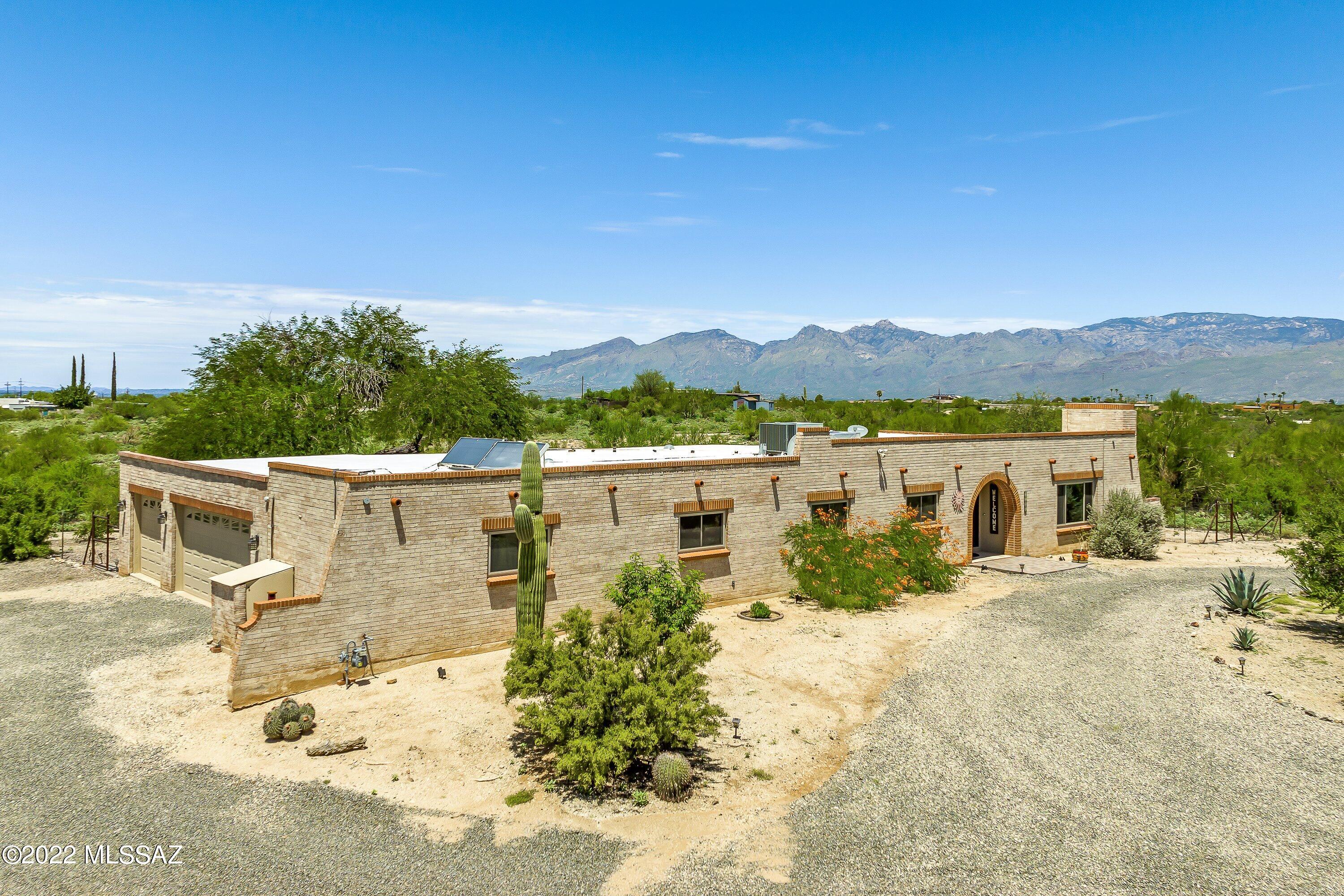Looking for Privacy and views, but want to still be close to everything?  Well you found it!  This beautifully updated , 9 acre horse property home has it all!  360 views of the Mountains, plus you can watch the sunset from your screened in Porch. EXTREMELY RARE & PRIVATE property near Saguaro National Park East w/ miles of trails & features 2 horse stalls w/ water, electric & tack room, and chicken coop!  You'll love the ranch style 2,345 sq ft home, updated in 2019.   4 bedrooms, 2.5 baths, large living rm w/ picture windows & stone fireplace, spacious kitchen w/ granite slab counter, family rm, formal dining rm & attached 3 car garage + storage room/workshop. Rich Alderwood doors, ceramic wood tile floors throughout. NO HOA. Tanque Verde Schools SR zoning allows potential for lot split,