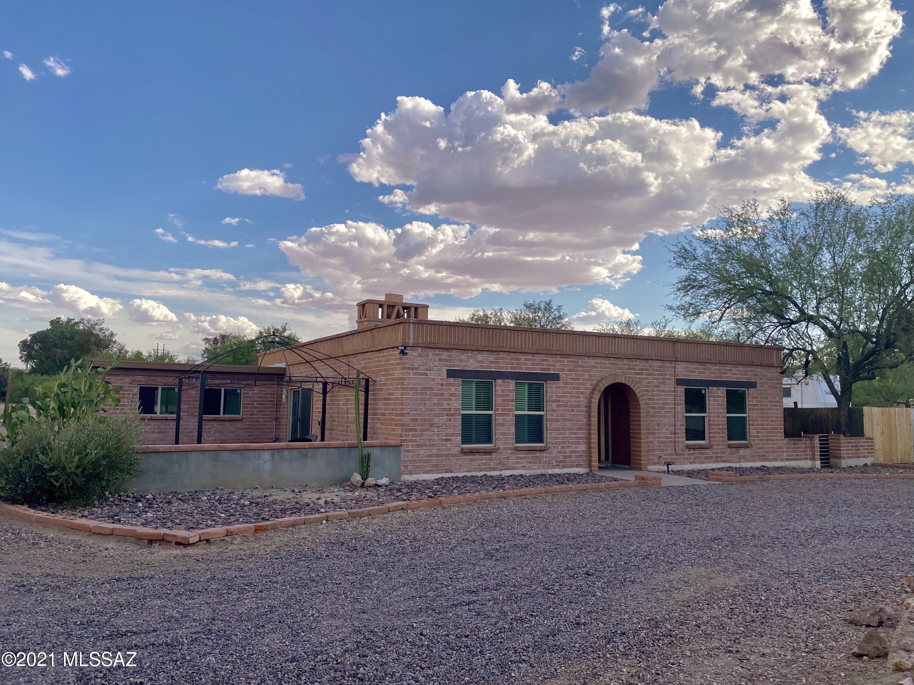 Rare Find! Loads of character in well maintained 4  bedroom 2 bath burnt adobe home located on 1.98 acres of SH zoned horse property just off Ina & I-10.  See thru fireplace to dining/living, knotty alder kitchen cabinets, solid wood doors, updated baths & large covered back patio & side paver patio, private registered well (no shares!), TWO septic systems w/ separate utility meters for RV mobile or development.  Attached 1.5 car garage, pole barn with additional RV hookup, horse stalls, and plenty of FLAT buildable land.  Zoning permits one house and guest house/mobile per acre for potentially 4 residences with easy ingress/egress along the lot perimeter. Great income potential as AirBnB &/or income from RV/mobile or development potential. LOADS OF VALUE for owner occupant & investors!