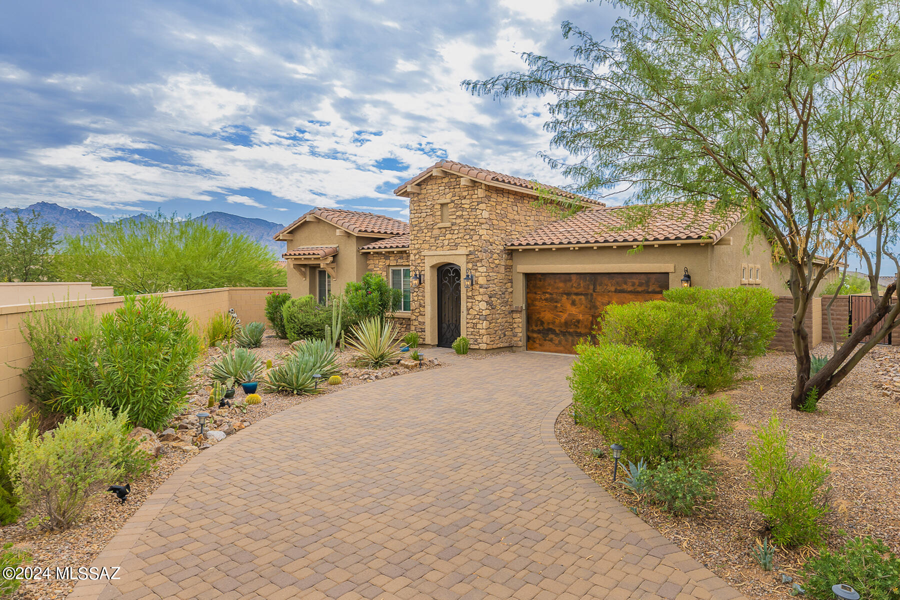 Exceptional 4BR/3BA (3,061 sq ft) Contemporary in gated Summit North at Center Pointe Vistoso boasts additional Den and Media room, resort worthy yard with pool, 3-car tandem garage and breathtaking Catalina views from inside & out. You'll be greeted by a brick paver drive, distinctive garage doors and soaring, stacked stone entry with wrought iron gate. Inviting front paver courtyard flows to an elegant, open concept living space displaying neutral décor, high ceilings & doors plus center-pull sliding glass doors to patio. Gourmet kitchen boasts gorgeous granite countertops, large center island with breakfast bar, breakfast nook, 5-burner gas cooktop, black stainless appliances including dual ovens plus walk-in pantry. You'll also enjoy a formal dining room with stacked stone accent wall, den/office with dual sliding barn doors, plus large, open media room in guest wing with mountain views. Private Owner's suite with bay window and patio access affords a luxury bath with gorgeous dual-sink vanity, open glass-front shower plus room length walk-in closet. This incredible home also features stunning, ceramic plank flooring throughout, wood slat blinds, elegant lighting fixtures, spacious laundry room with sink, water softener, zoned heating & cooling, alarm system and plenty of storage space. Luxurious Travertine tile highlights the rear covered patio and also extends to an outer patio with BBQ island, decorative turf lawn and large, heated pool with sun shelf, raised spa and triple fountains. Professionally landscaped and maintained, this home is perfect for the most discerning buyer. Center Pointe amenities include a clubhouse, park with playground, pool/spa, splashpad, firepit ramada and walking trail.