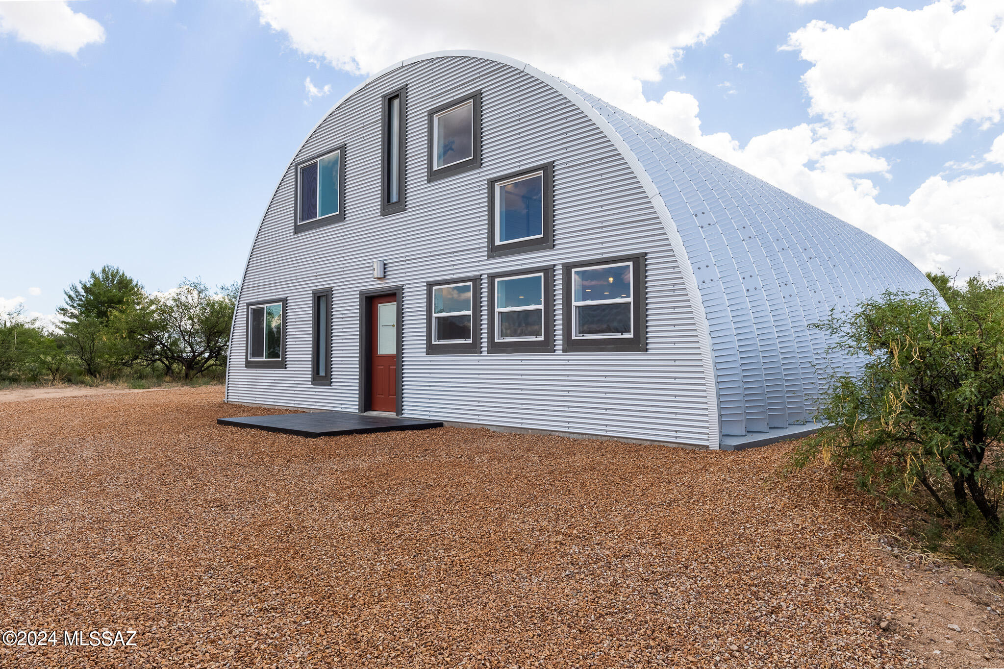 Spectacular 2024 built steel arch barndominium in Mescal area, The massive 20' high steel arches cover 2100 sq ft total, 1200 sq ft of it is a garage/shop with 2 roll up doors able to fit high vehicles. The front side is 1230 sq ft of well laid out living space with 2 bedrooms and 2 baths. The exposed ductwork and enclosed vapor ligh fixtures set an industrial vibe while the cable railing exposed steel staircase and. polished concrete floors create a modern feel. The kitchen boasts a counter depth refrigerator with ice make hook up, all plywood shaker cabinets, sleek sheet metal backsplash and large butcher block counter island that seats 4. Double pained windows, reflective galvanized heavy gauge corrugated steel siding, 3 ton 16 seer heat pump for heating and cooling. The galvanized steel arch reflects sun's heat and the interior is insulated to r38 through the entire arch. And the views from the upstairs loft are amazing!! New fence around the entire yard with key pad on the gate.