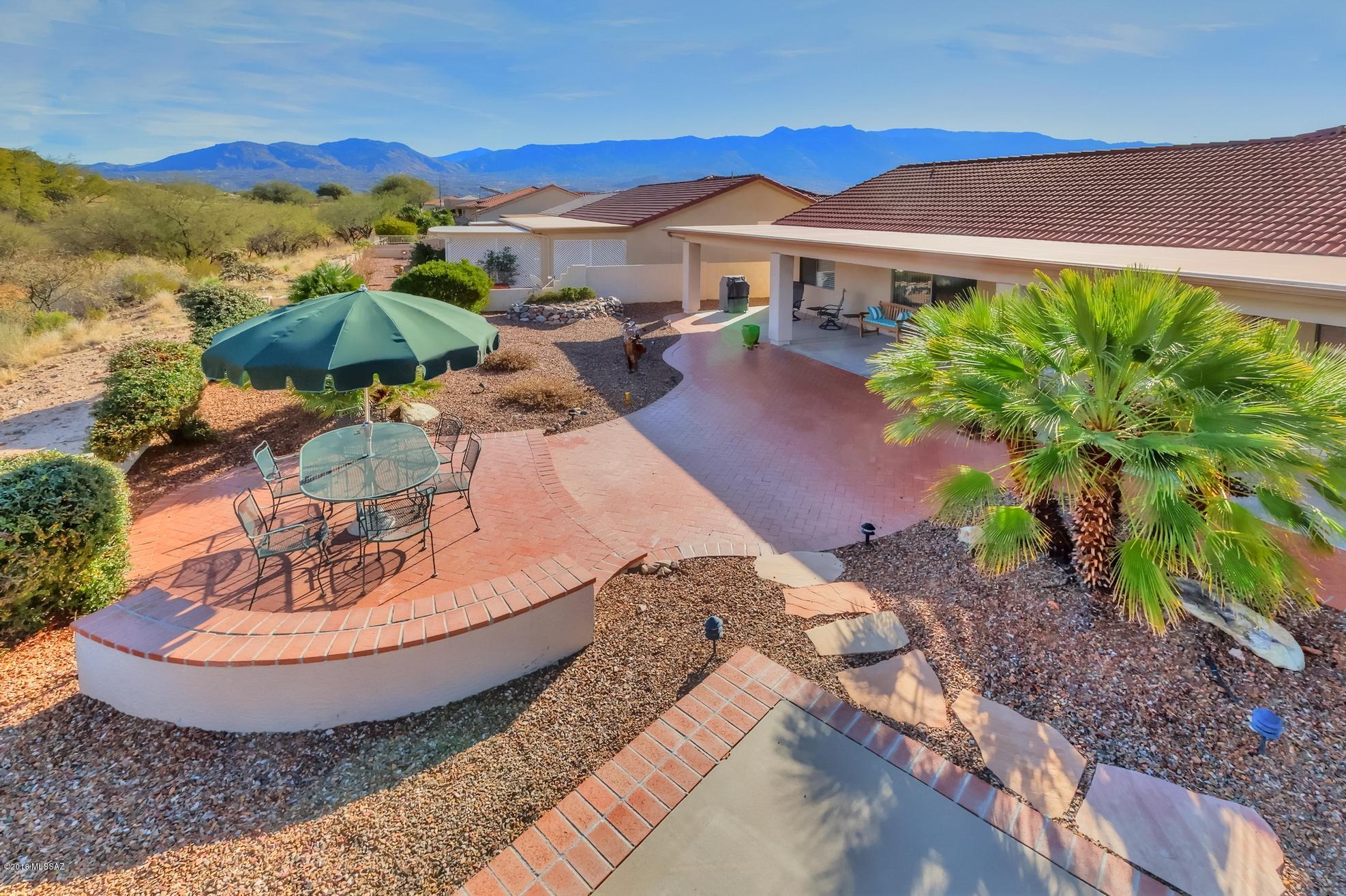 Welcome to this beautiful expanded Laredo model located on a lot that borders natural desert common area! New interior paint & carpeting make this home warm & inviting from the moment you step in to the great room of this open, split bedroom floor plan. The island kitchen features new granite counters, new stainless sink, disposal & faucet, maple cabinets, 4 burner gas stove, stainless steel appliances, pull outs & under counter lighting. The master suite is spacious with bay window, en suite with double sink vanity, new lighting, large shower w/grab bars & walk-in closet. Garage features 7 double door cabinets + workbench. Enjoy quiet time on the fully covered, private brick patio, watch the wild life or enjoy the golf course views beyond. This is a truly special SaddleBrooke home!