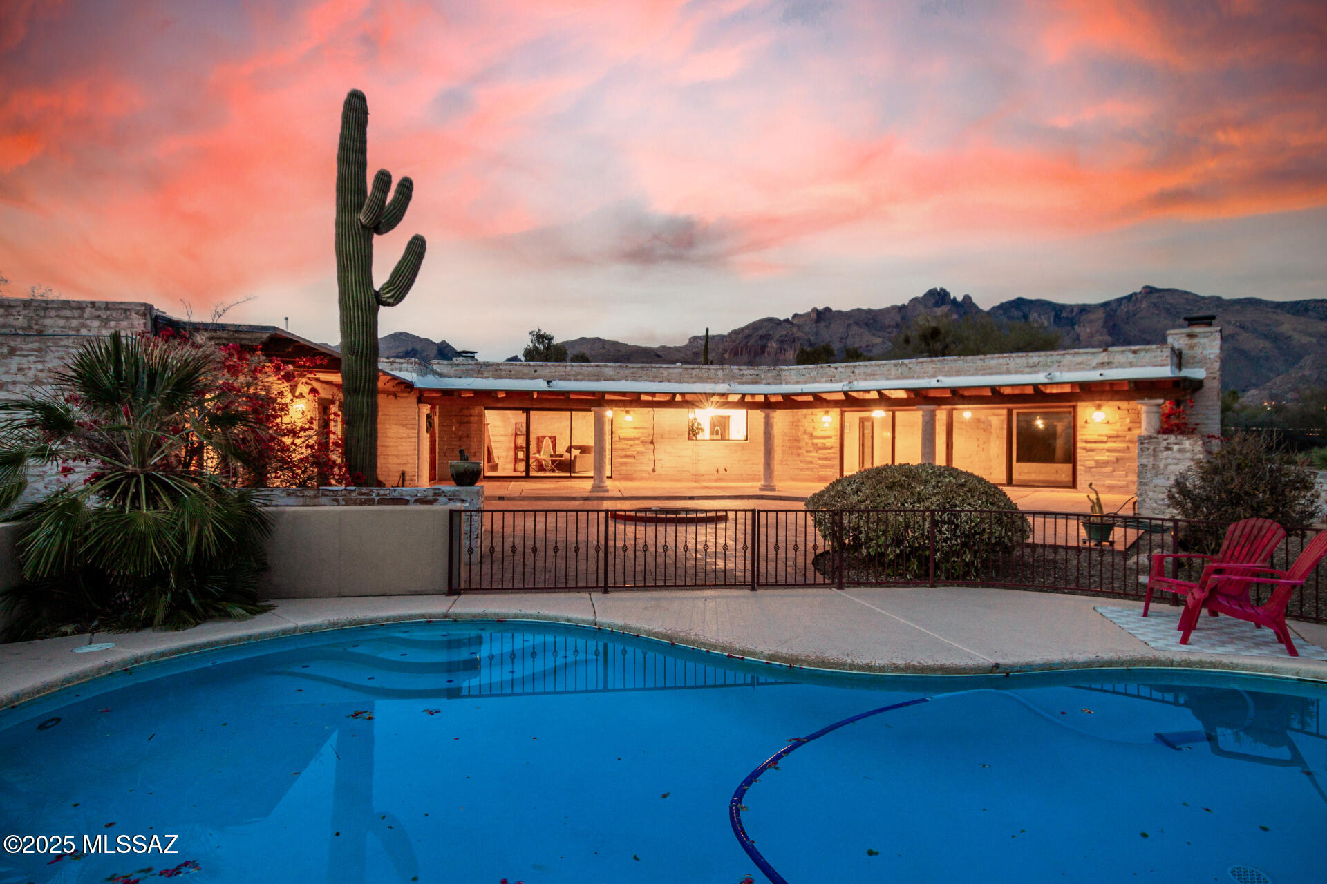 Nestled amidst majestic mountain & city views, this stunning 6-bedroom Catalina Foothills jewel offers a harmonious blend of charm & functionality. Large main home with attached guest house. Inside, wood plank ceilings and exposed beams elevate the ambiance, while spacious living room boasts a classic beehive fireplace. Cozy family room with gas fireplace provides additional warmth and comfort. Sleek kitchen features stainless steel appliances, granite counters, neutral cabinets, and a center island with breakfast bar. The serene primary suite offers a private bathroom with dual sinks. Step outside to a backyard paradise complete with a covered patio, refreshing pool, and ample space to entertain. All this plus Catalina Foothills school district & world-class shopping & dining steps away!